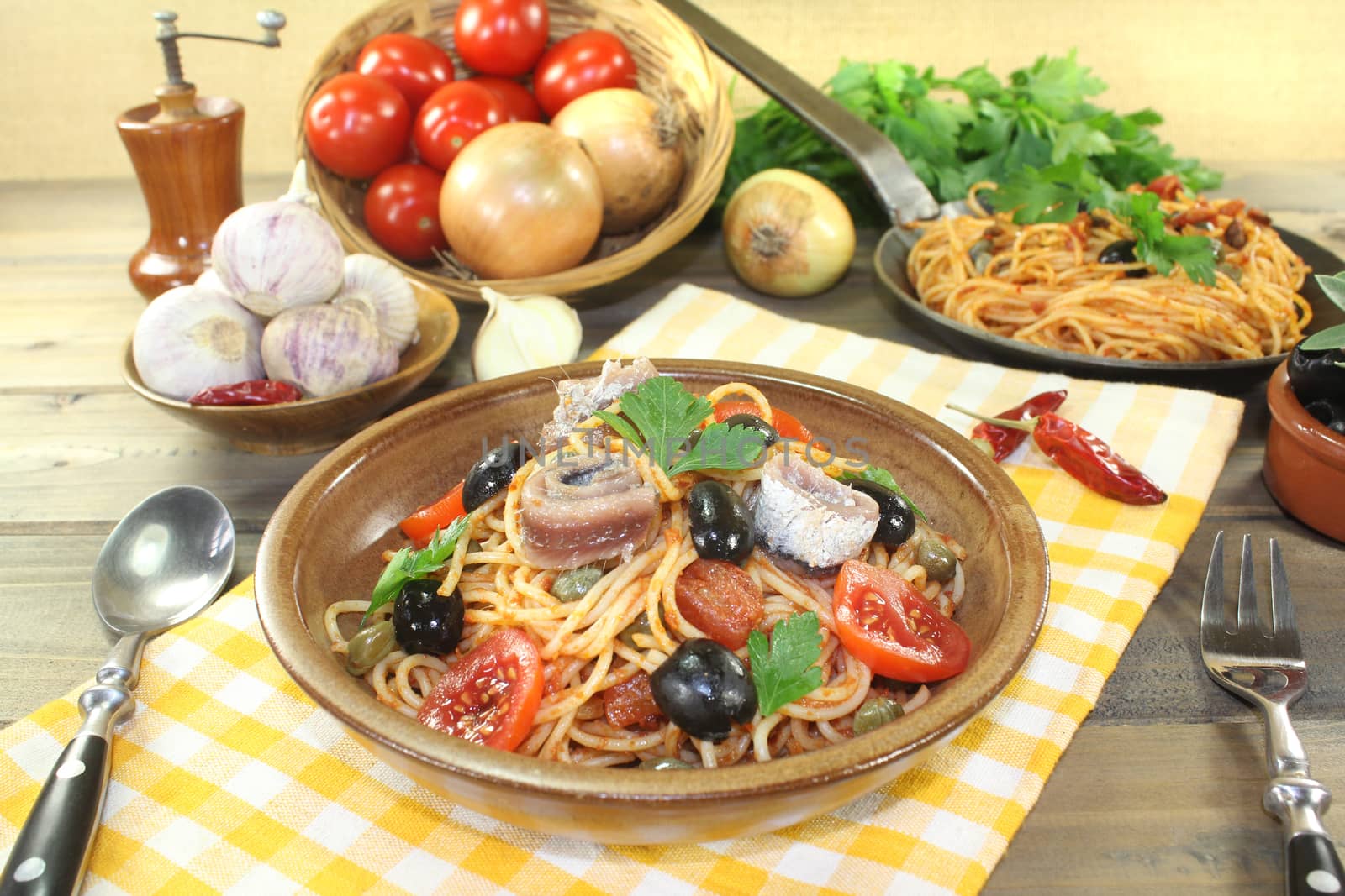 Spaghetti alla puttanesca with capers and tomatoes on a napkin