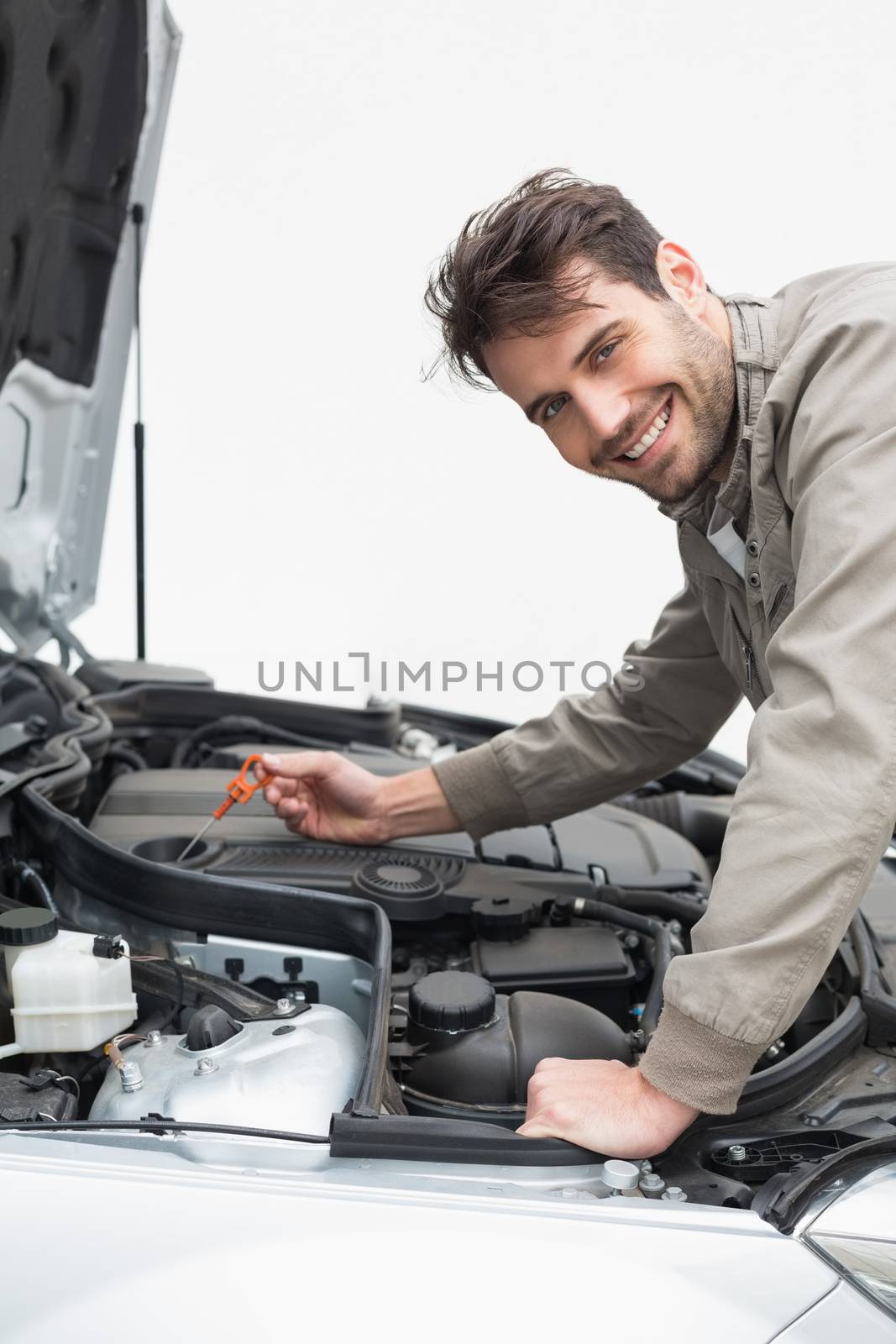 Man using dipstick to check oil by Wavebreakmedia