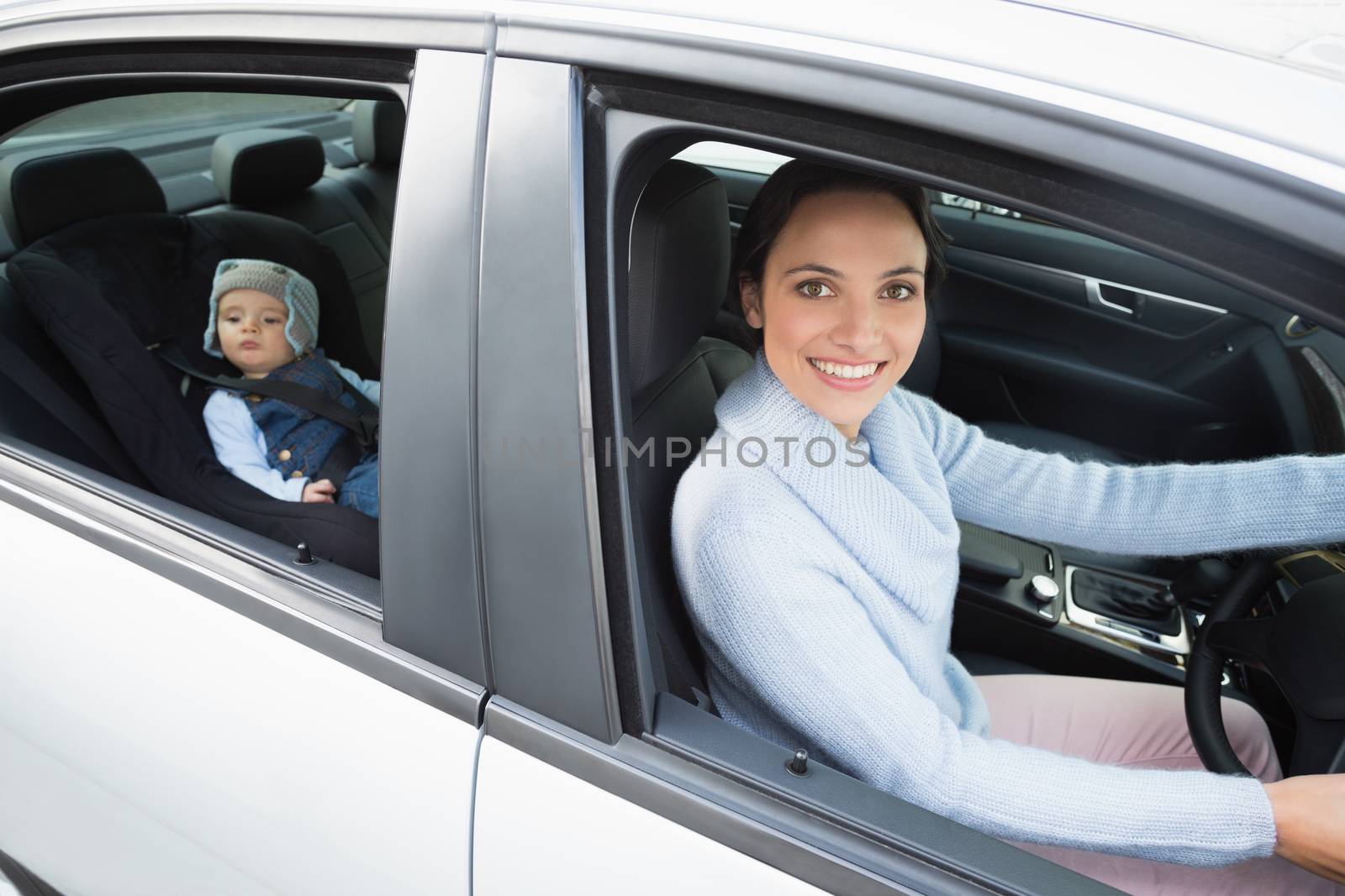 Mother driving with her baby in the car seat in her car