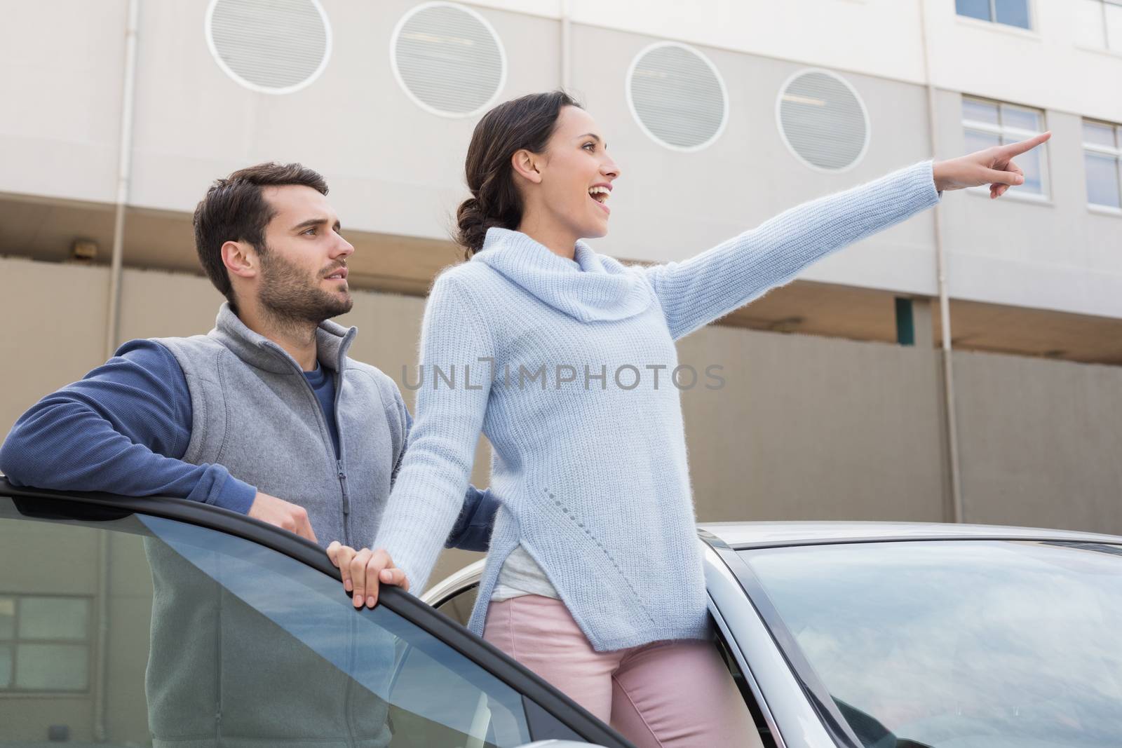 Young couple smiling together outside their car