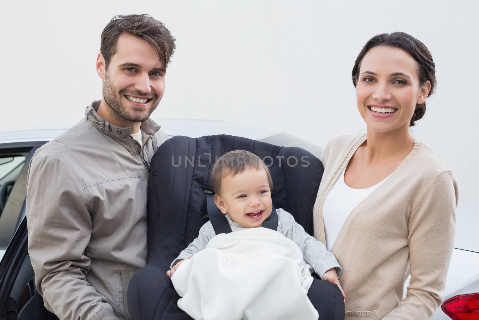 Parents carrying baby in his car seat by Wavebreakmedia
