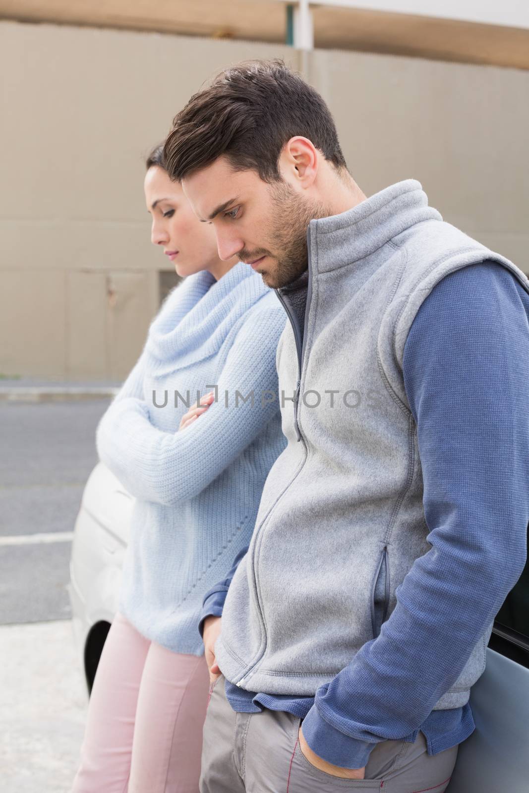 Young couple having an argument outside their car