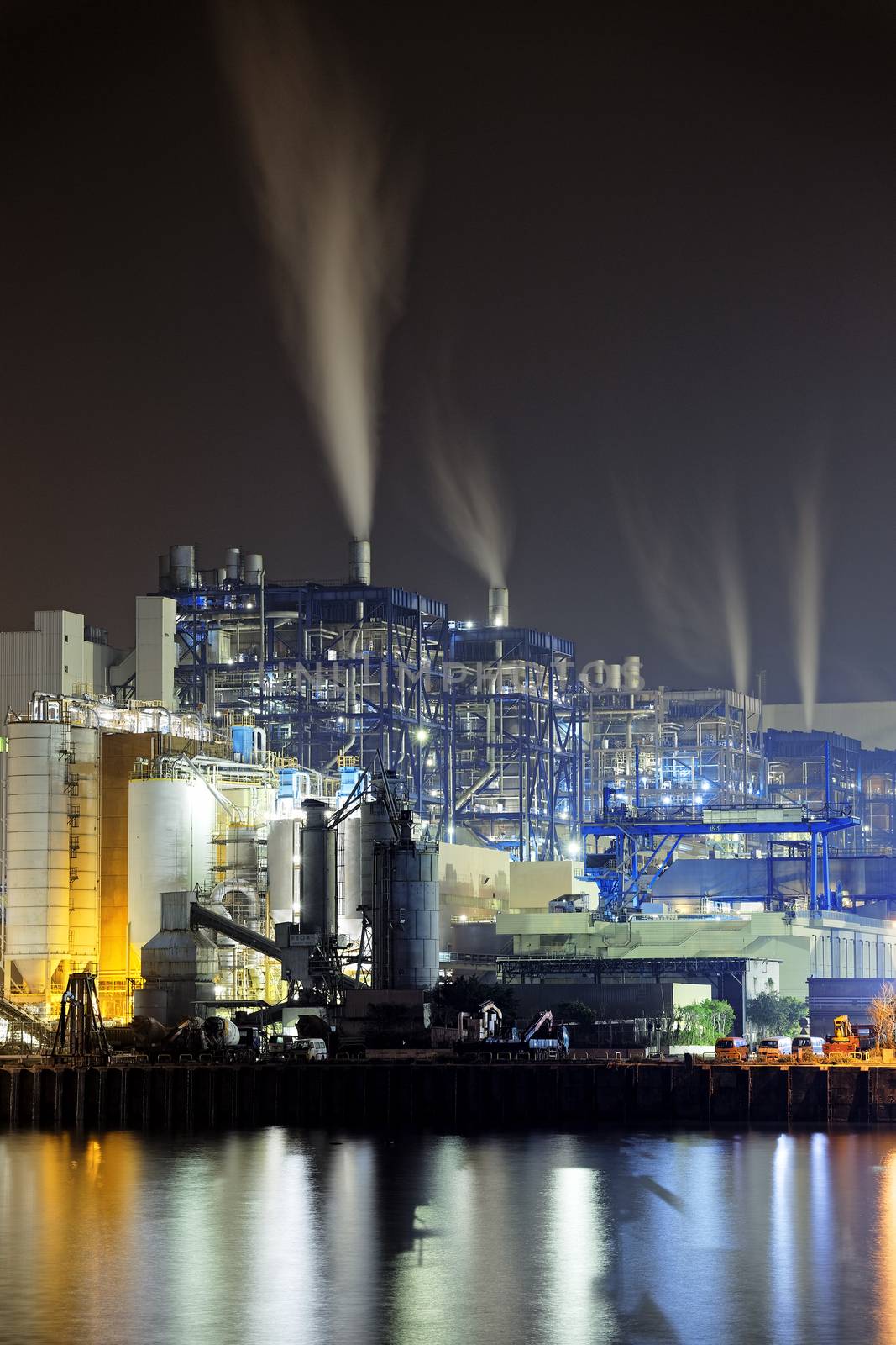 power station at night with smoke by cozyta