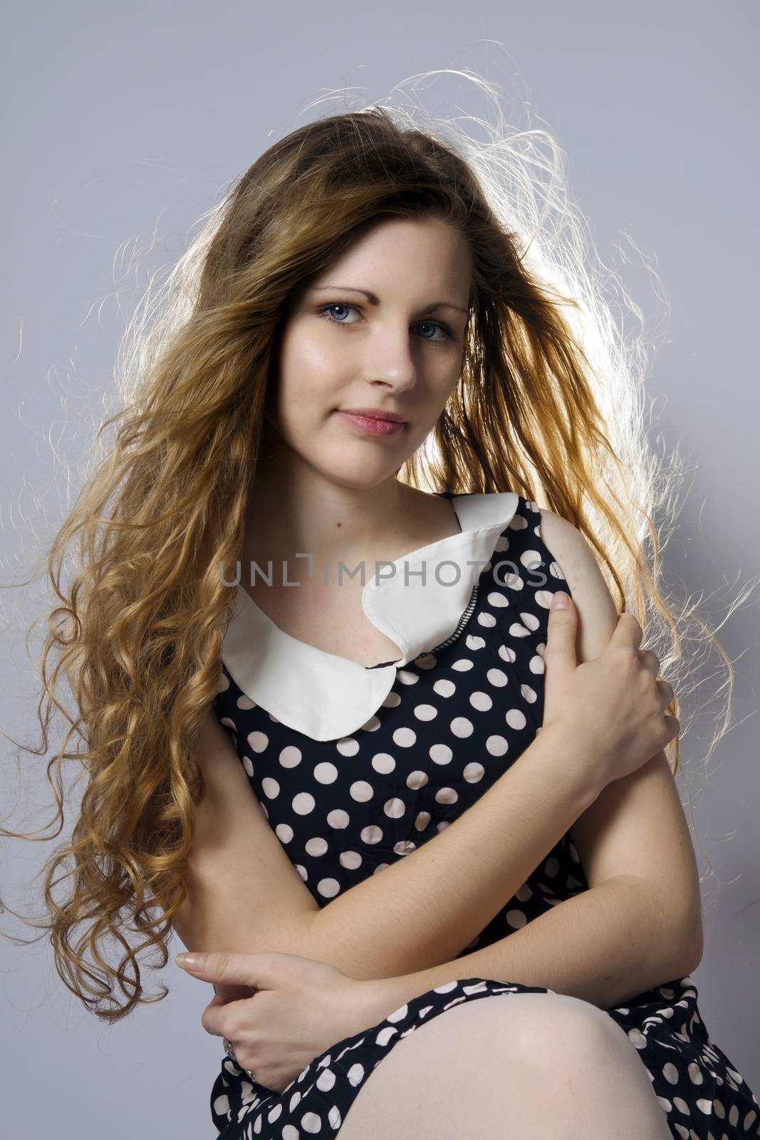 Young long-haired curly blonde woman presented beautiful natural long curly blond hair