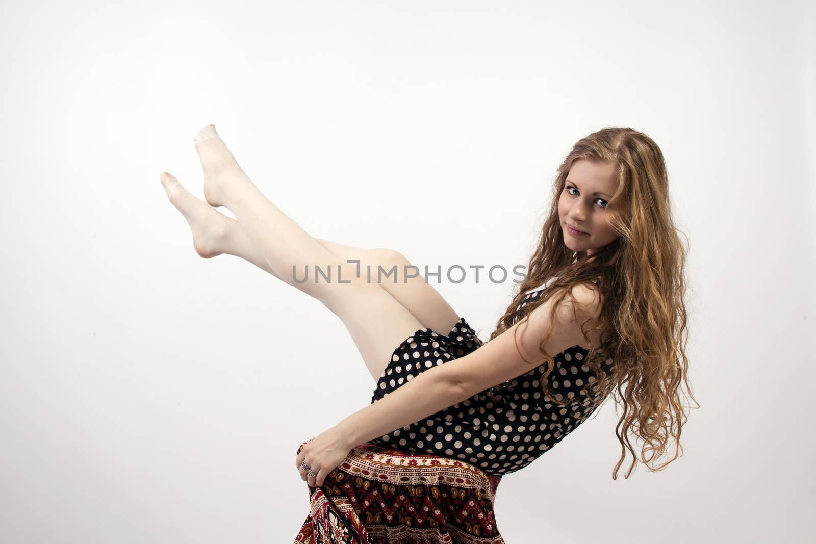 Young long-haired curly blonde woman sitting on chair, covered with mandala