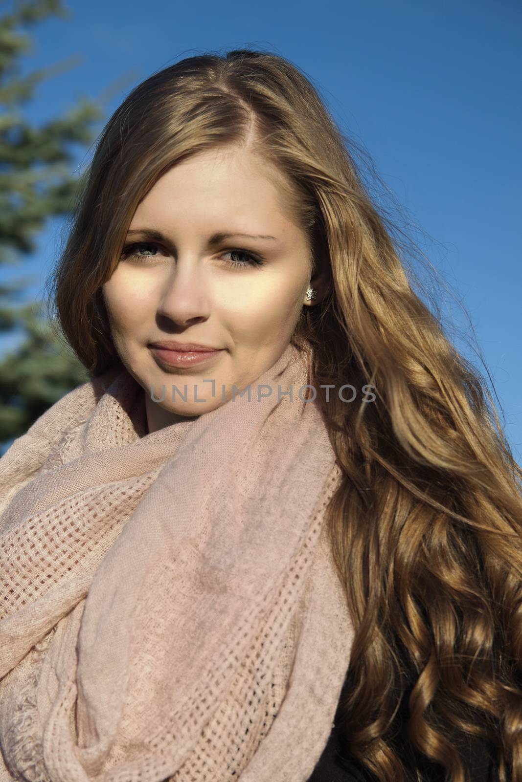 Young long-haired curly blonde woman presented beautiful natural long curly blond hair