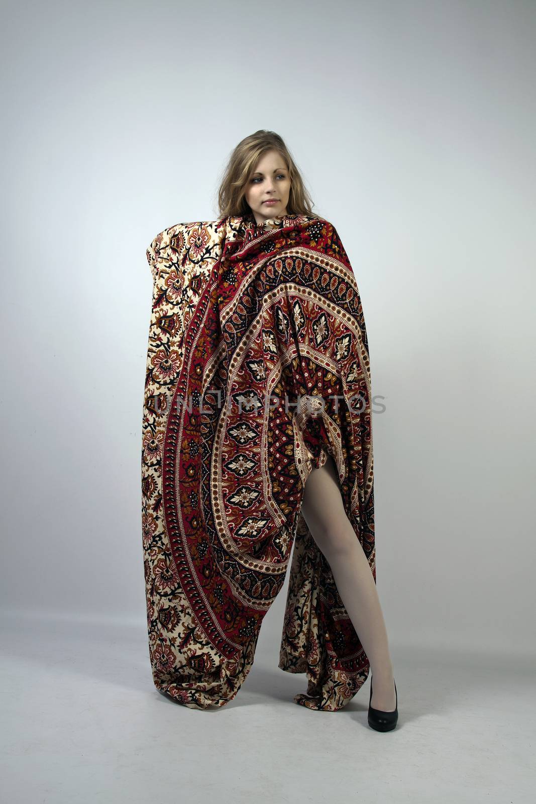 Young long-haired curly blonde woman posing wrapped in a mandala