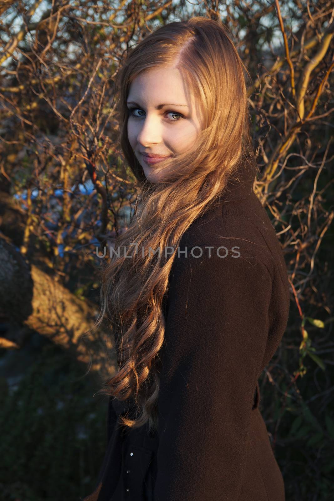 Young long-haired curly blonde woman presented beautiful natural long curly blond hair