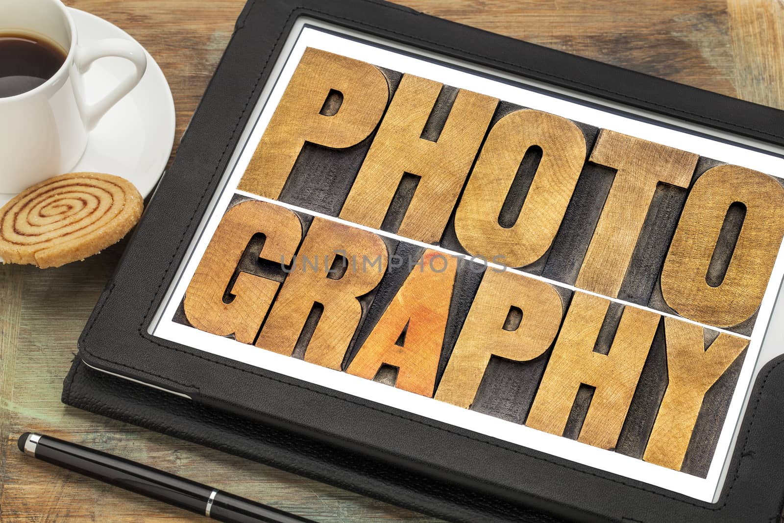 photography word abstract in letterpress wood type on a digital tablet with cup of coffee