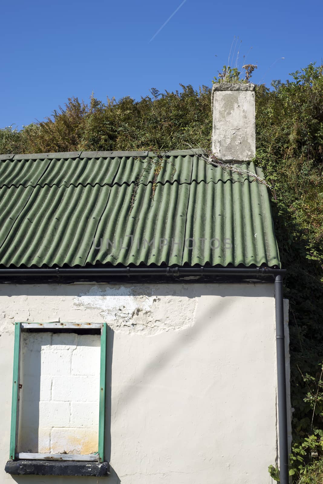 old white washed home with galvanised roof