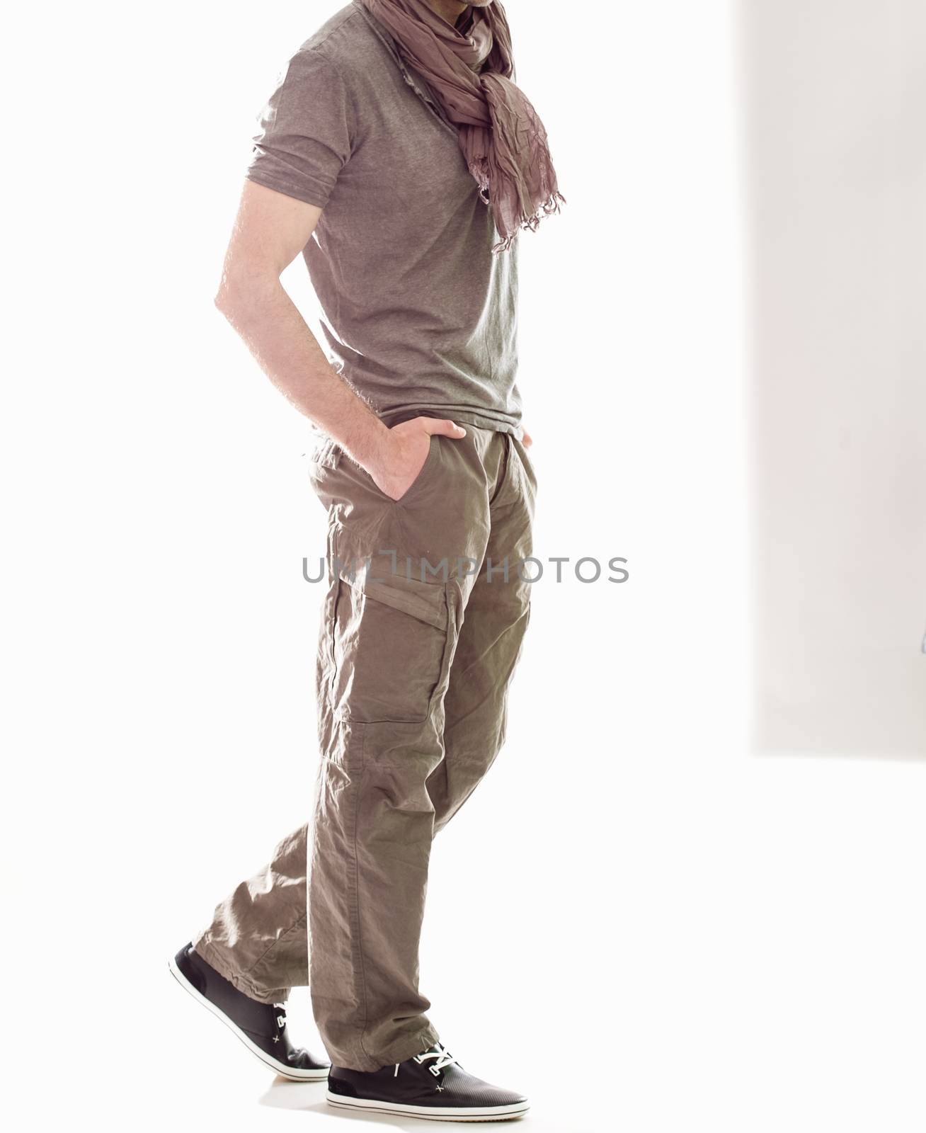 Elegant young handsome man in gray clothing. Studio fashion portrait.