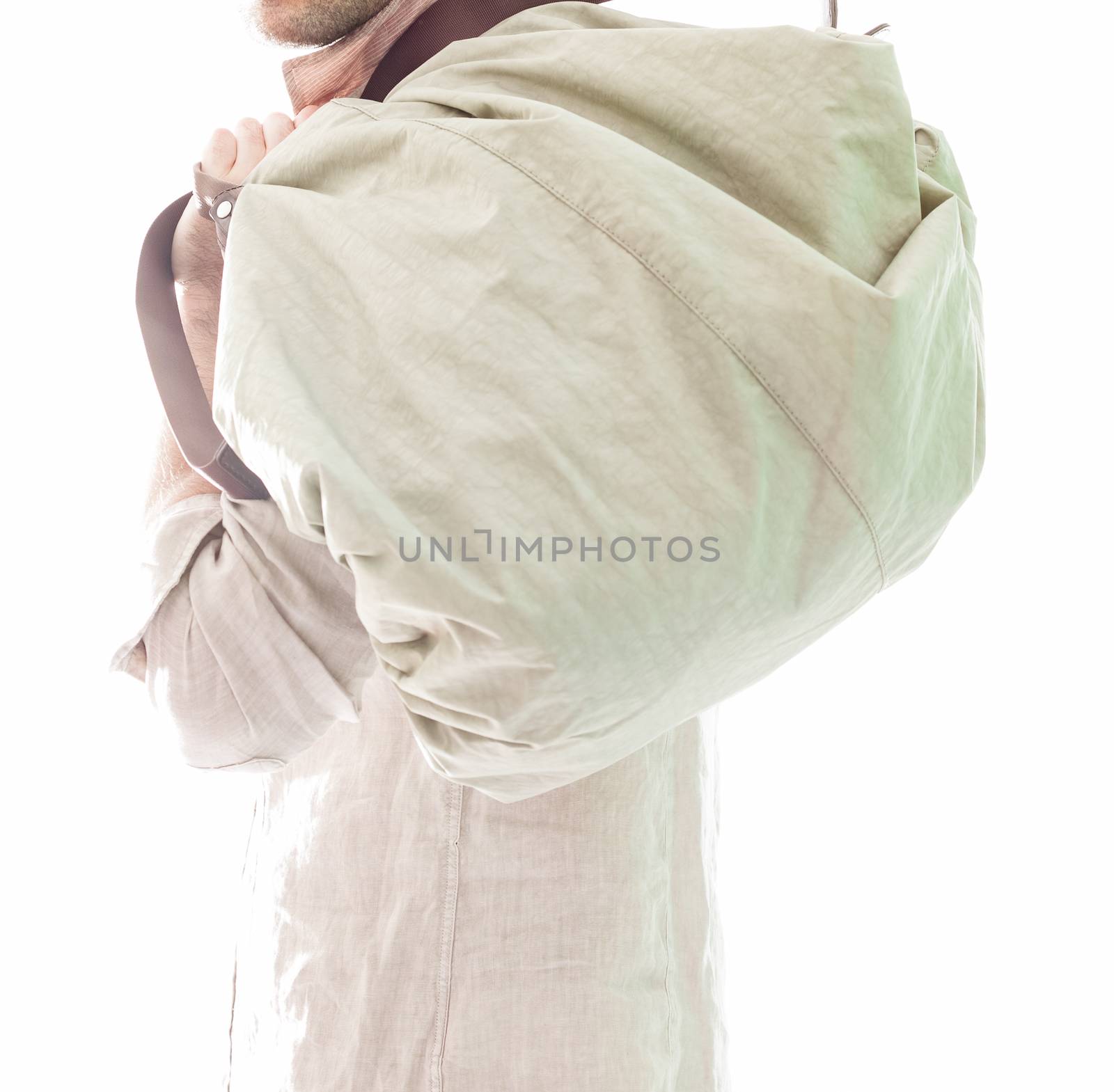 Elegant young handsome man in white clothing and bag. Studio fashion portrait.