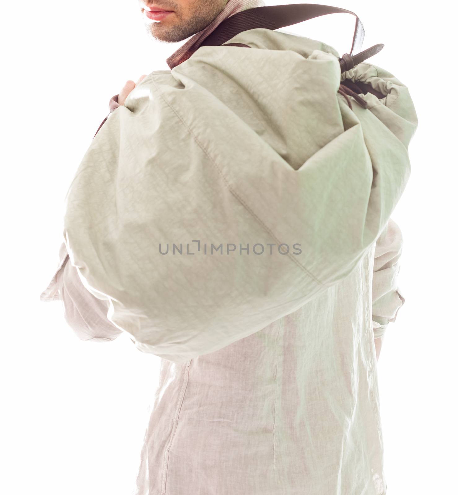 Elegant young handsome man in white clothing and bag. Studio fashion portrait.