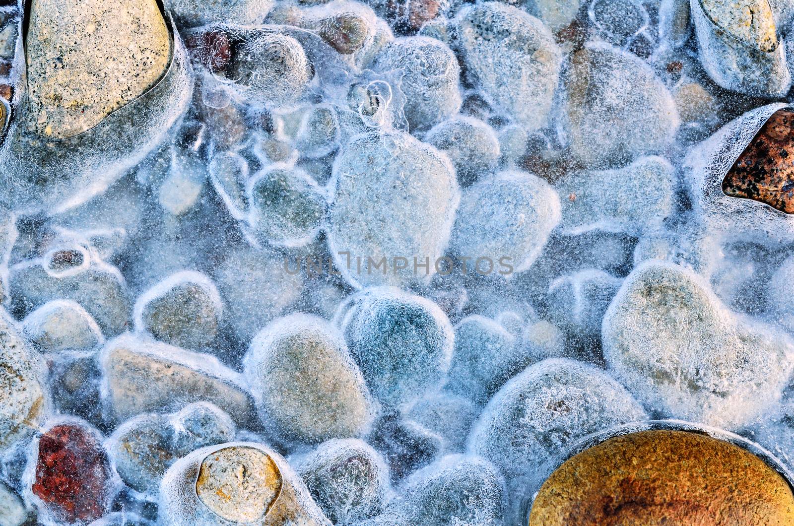 Frozen water on the pebbles on the seashore