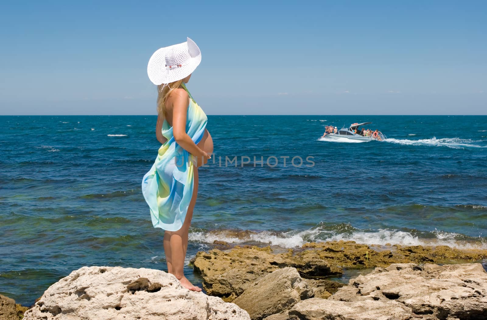 Crimea, the sea, rocks and a pregnant woman. Clear Skies.