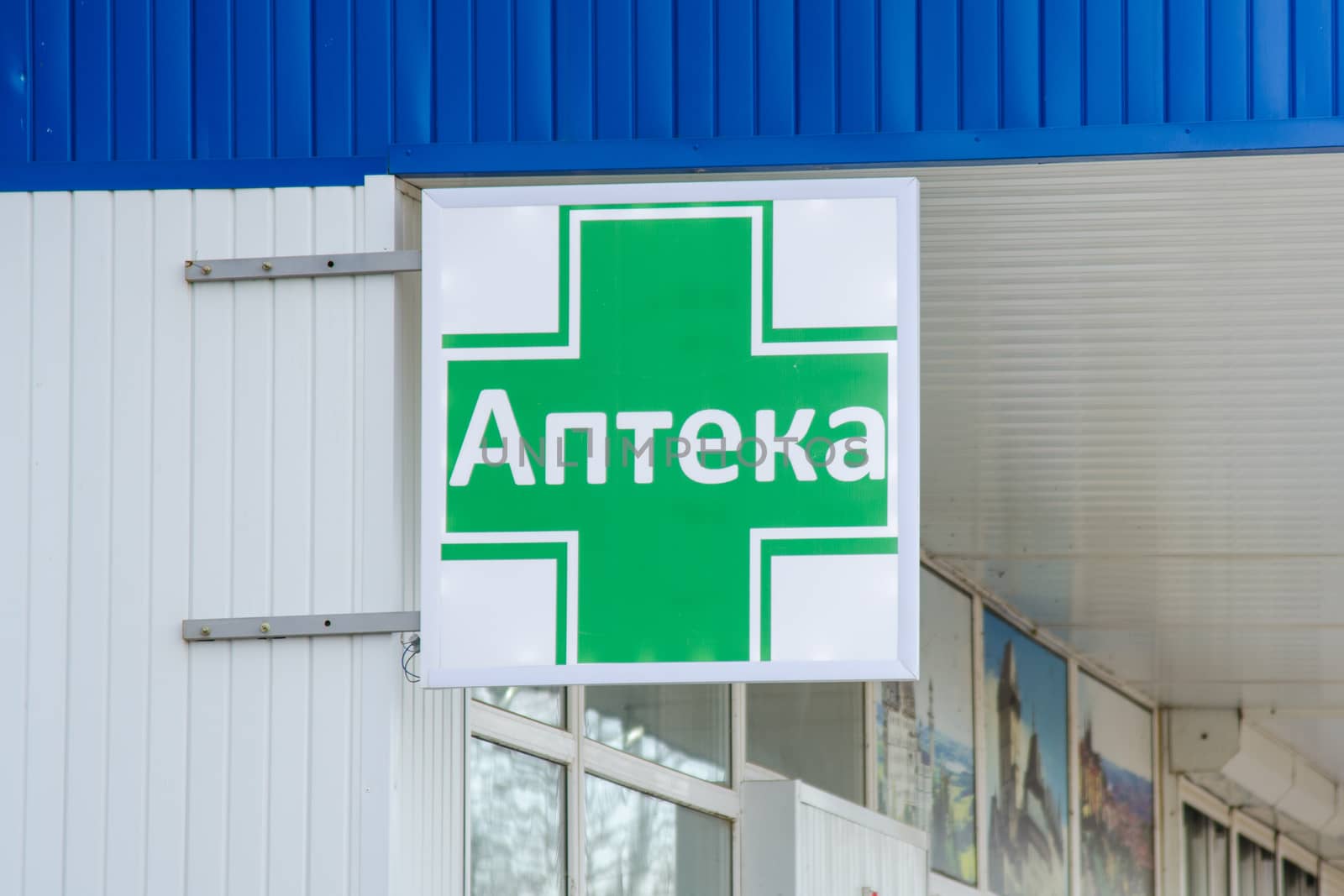 The inscription on the street sign - Pharmacy - on the green cross