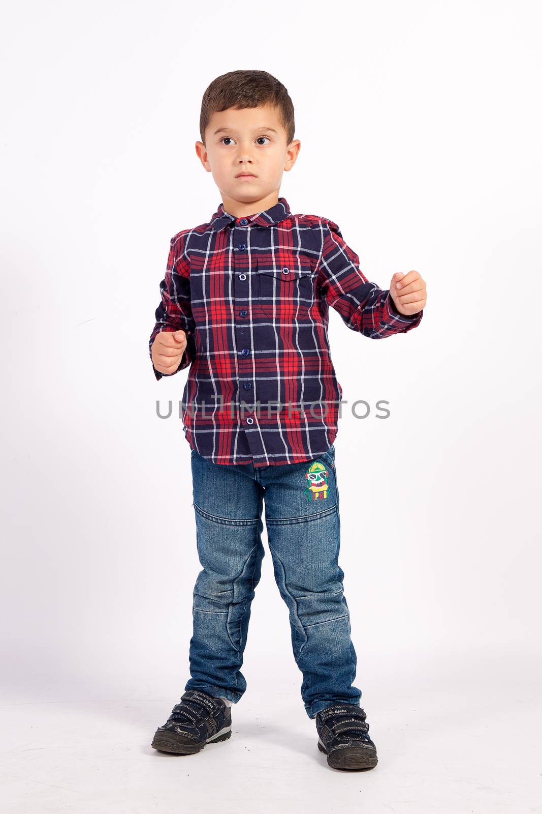 Little boy in checkered shirt in combat postures