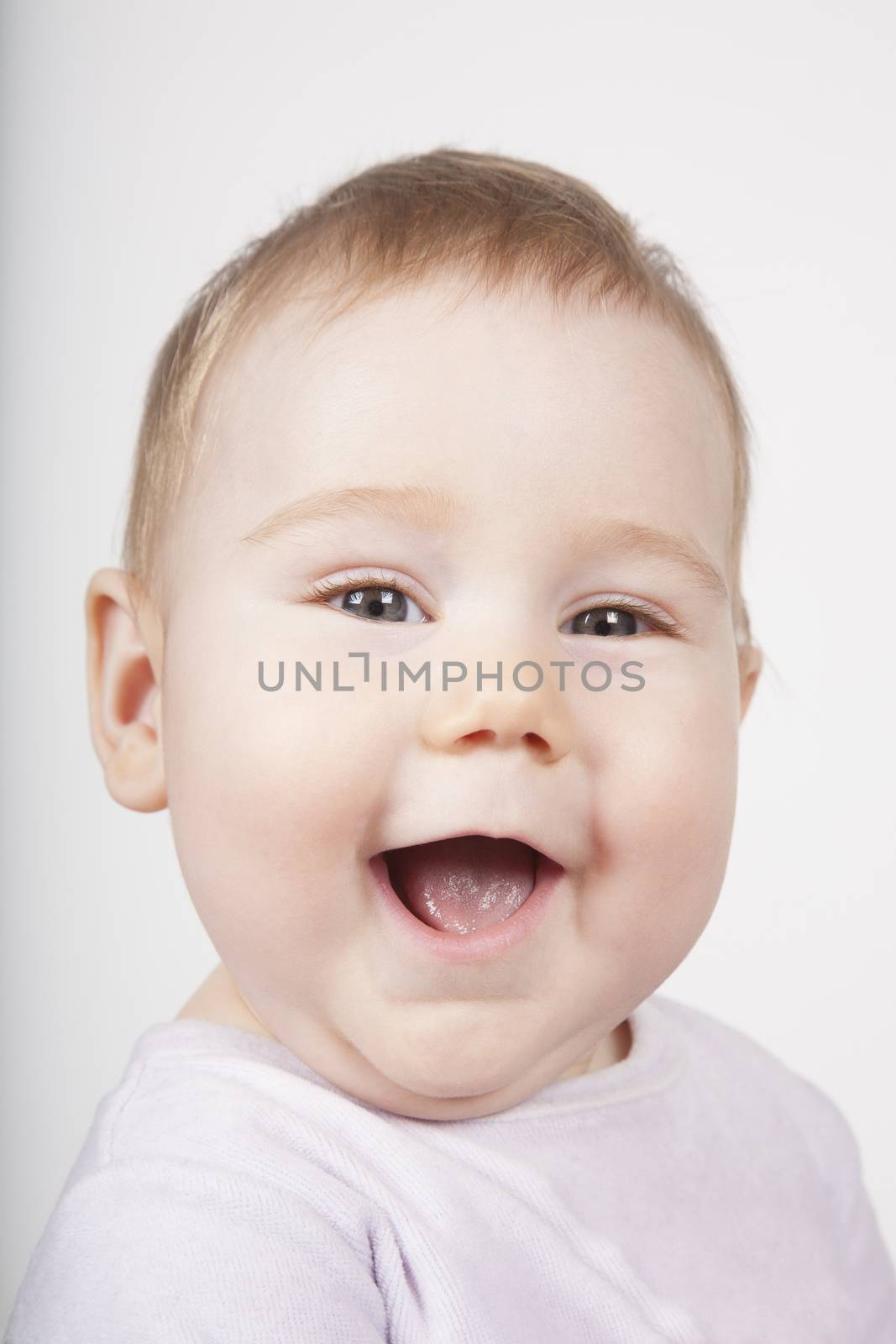portrait of eight months age blonde lovely cute baby pink velvet onesie smiling happy face isolated on white