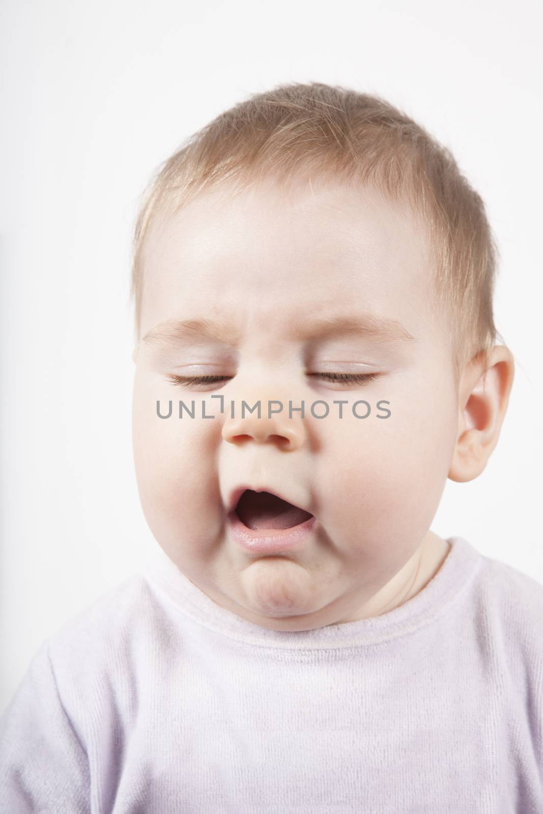 portrait of eight months age blonde lovely cute baby pink velvet onesie disgusted or sneeze face isolated on white