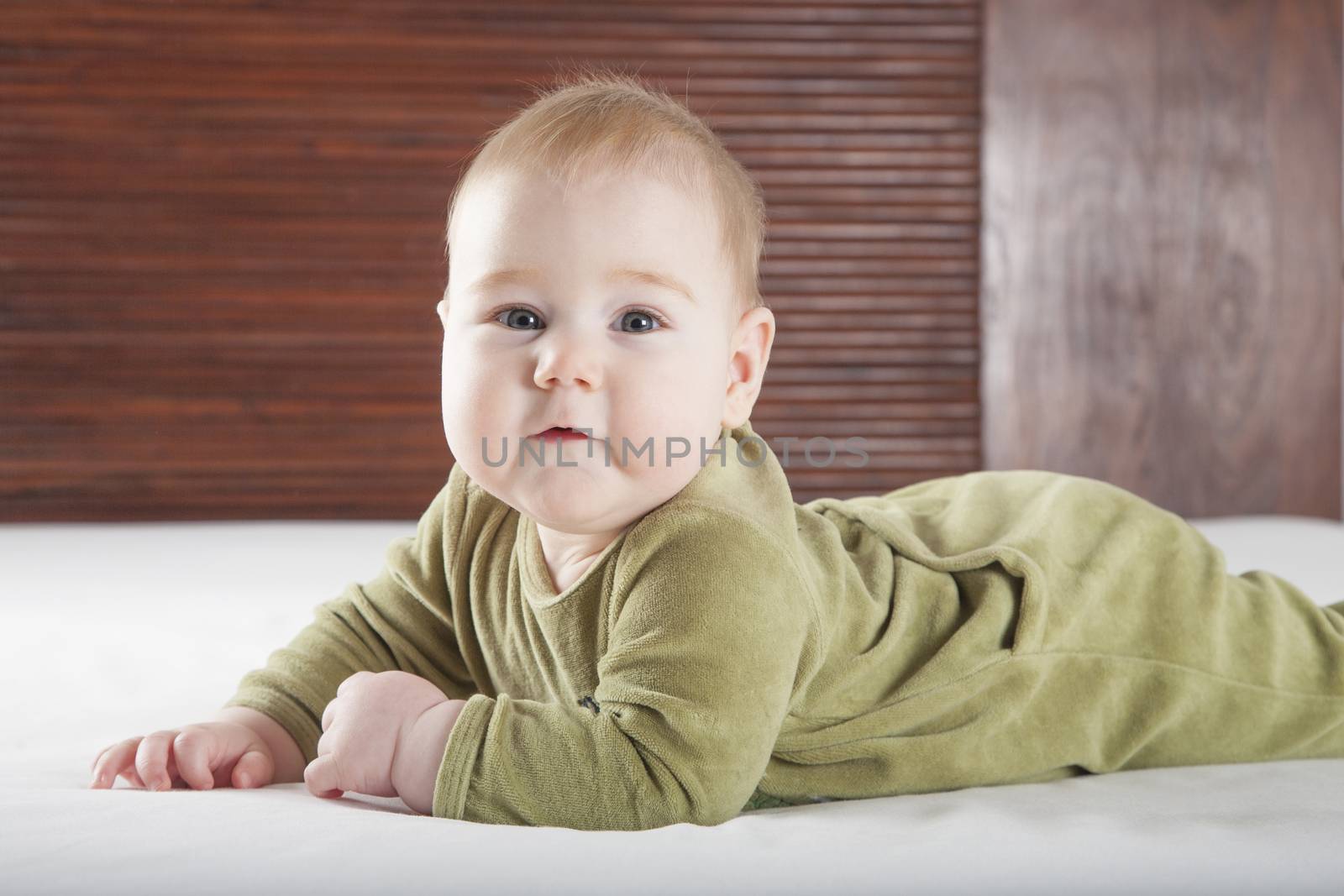 cute baby on bed looking by quintanilla