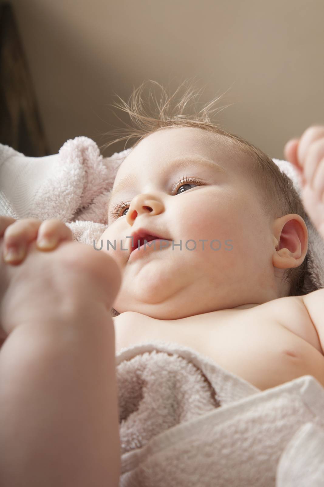 face of baby lying on towel by quintanilla