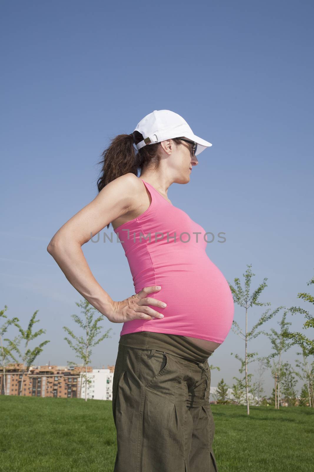 pink pregnant posing at park by quintanilla