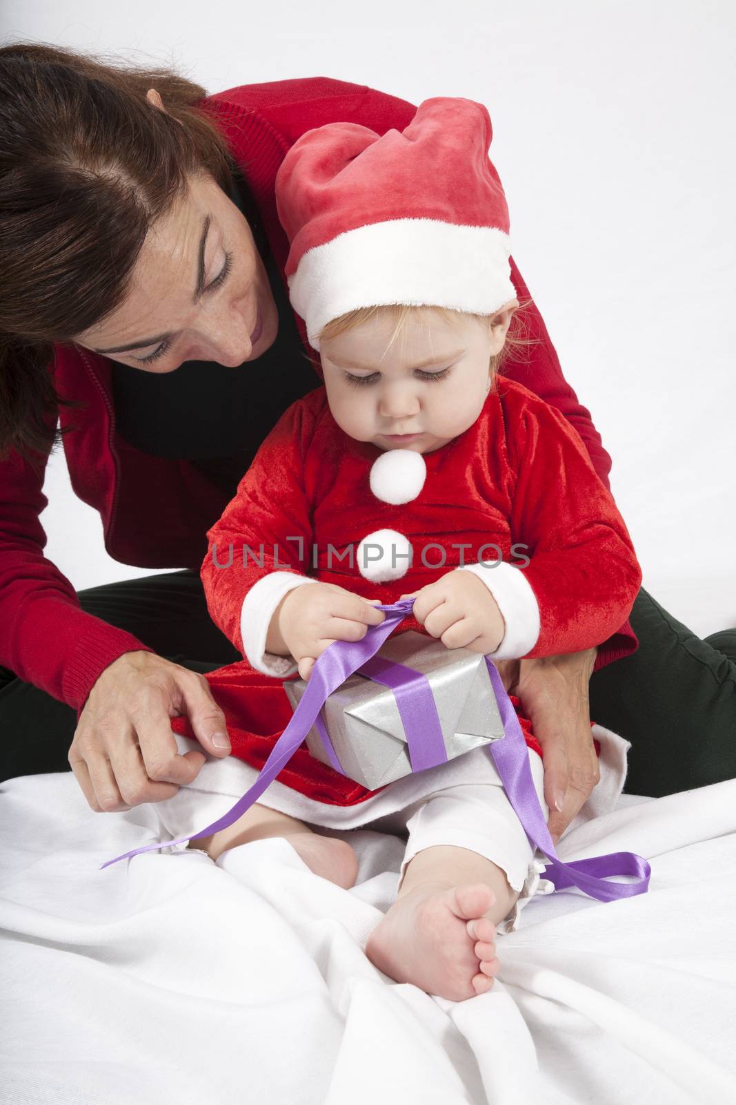 santa claus baby and mom opening gift by quintanilla