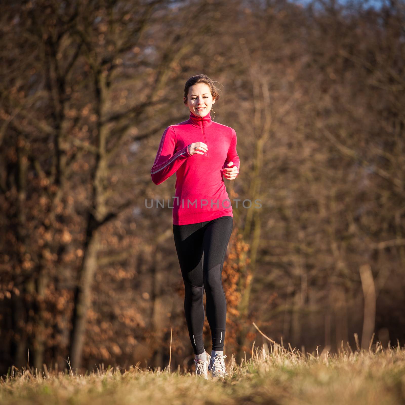 Young woman running outdoors on a lovely sunny winter/fall day  by viktor_cap