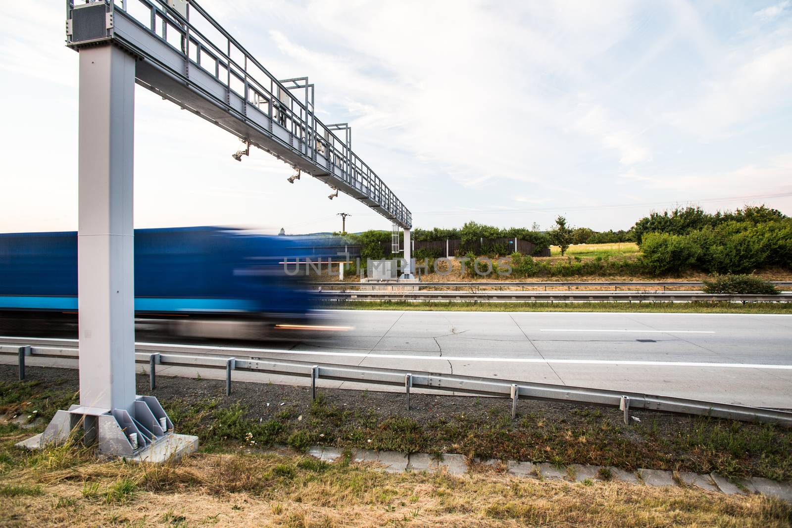 truck passing through a toll gate on a highway by viktor_cap