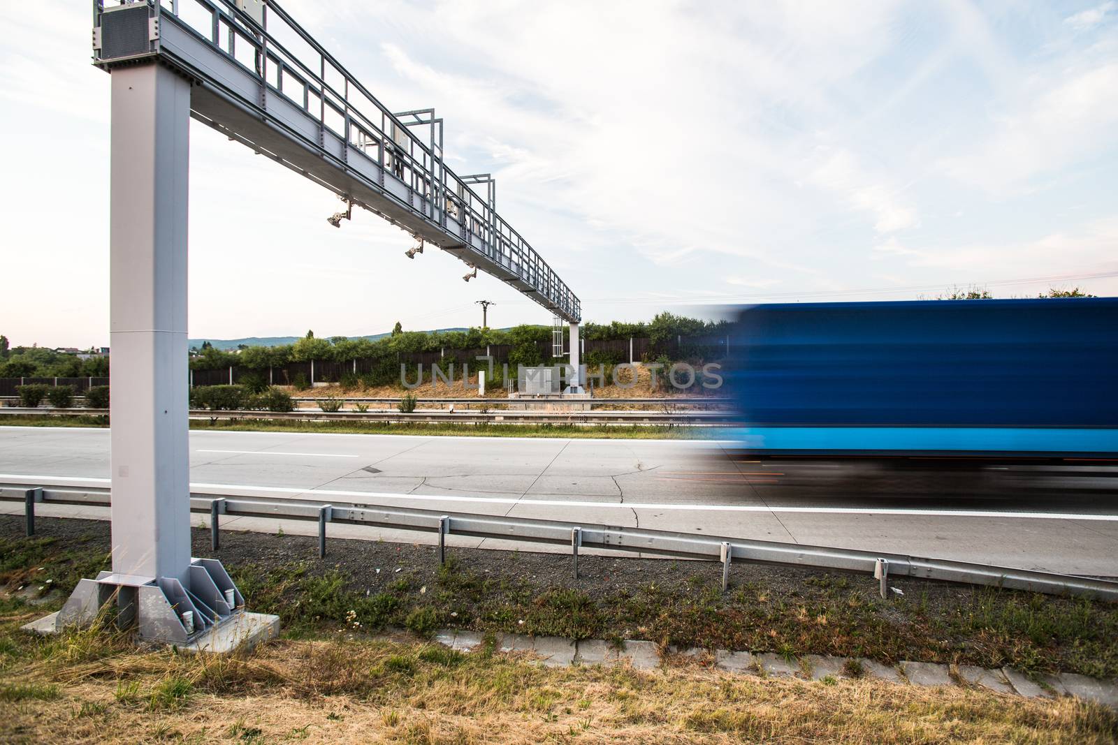 truck passing through a toll gate on a highway (motion blurred i by viktor_cap