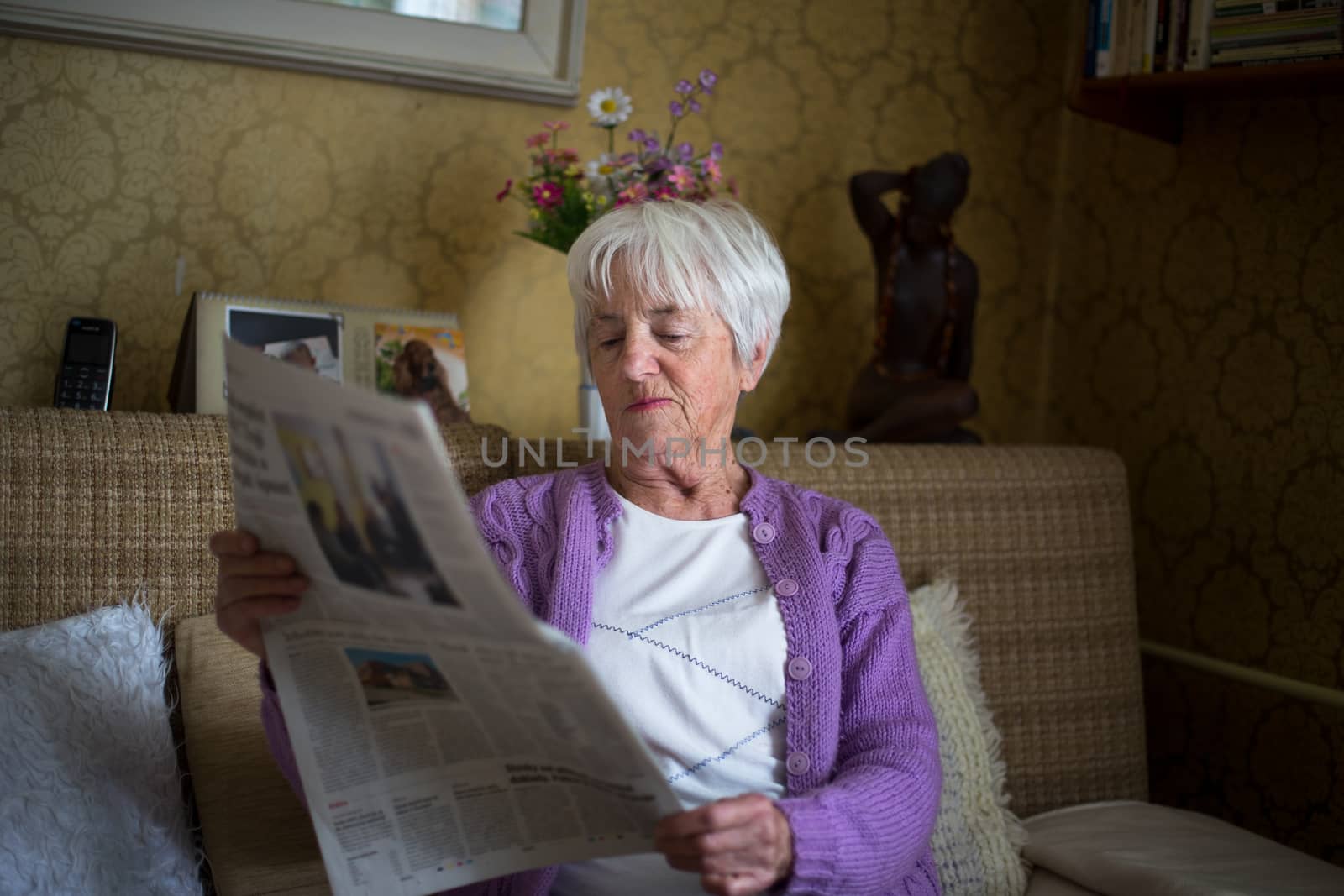 Senior woman reading morning newspaper by viktor_cap