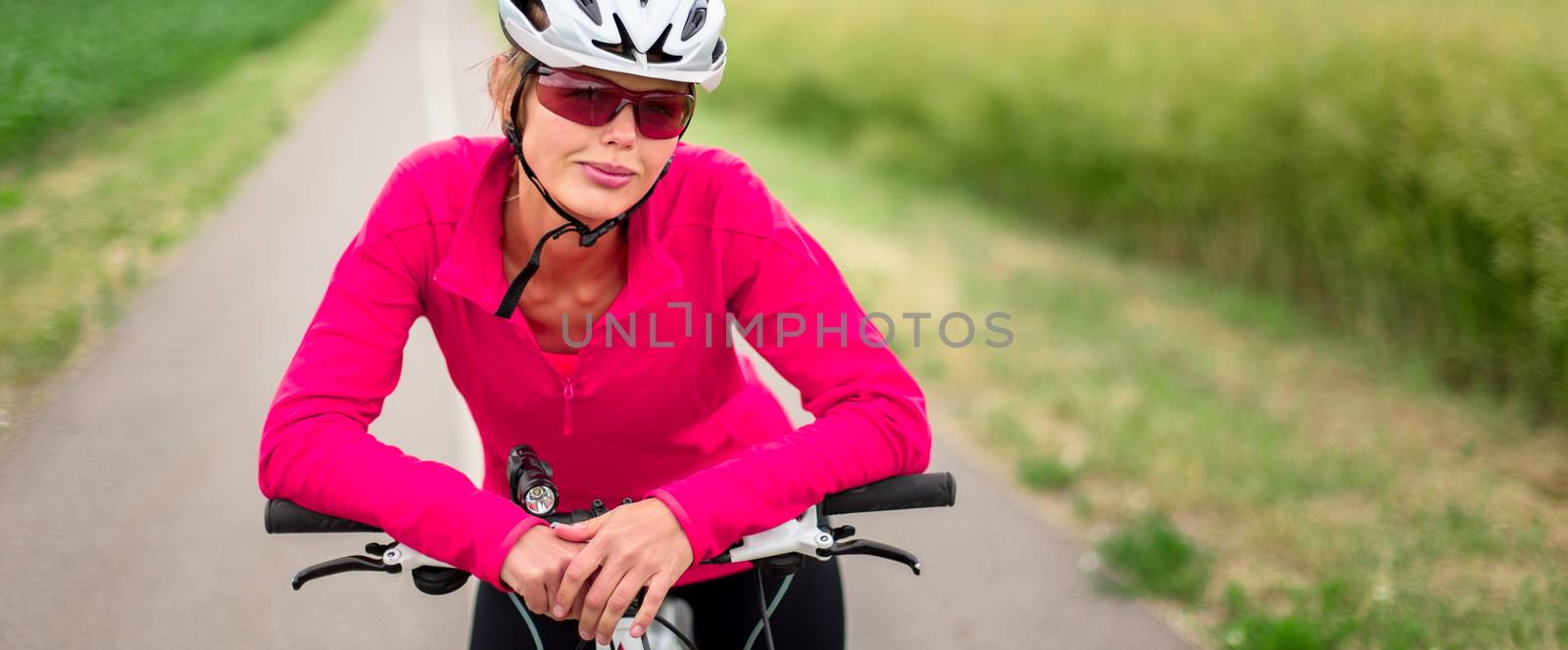 Pretty, young female biker outdoors on her mountain bike (shallow DOF; selective focus)