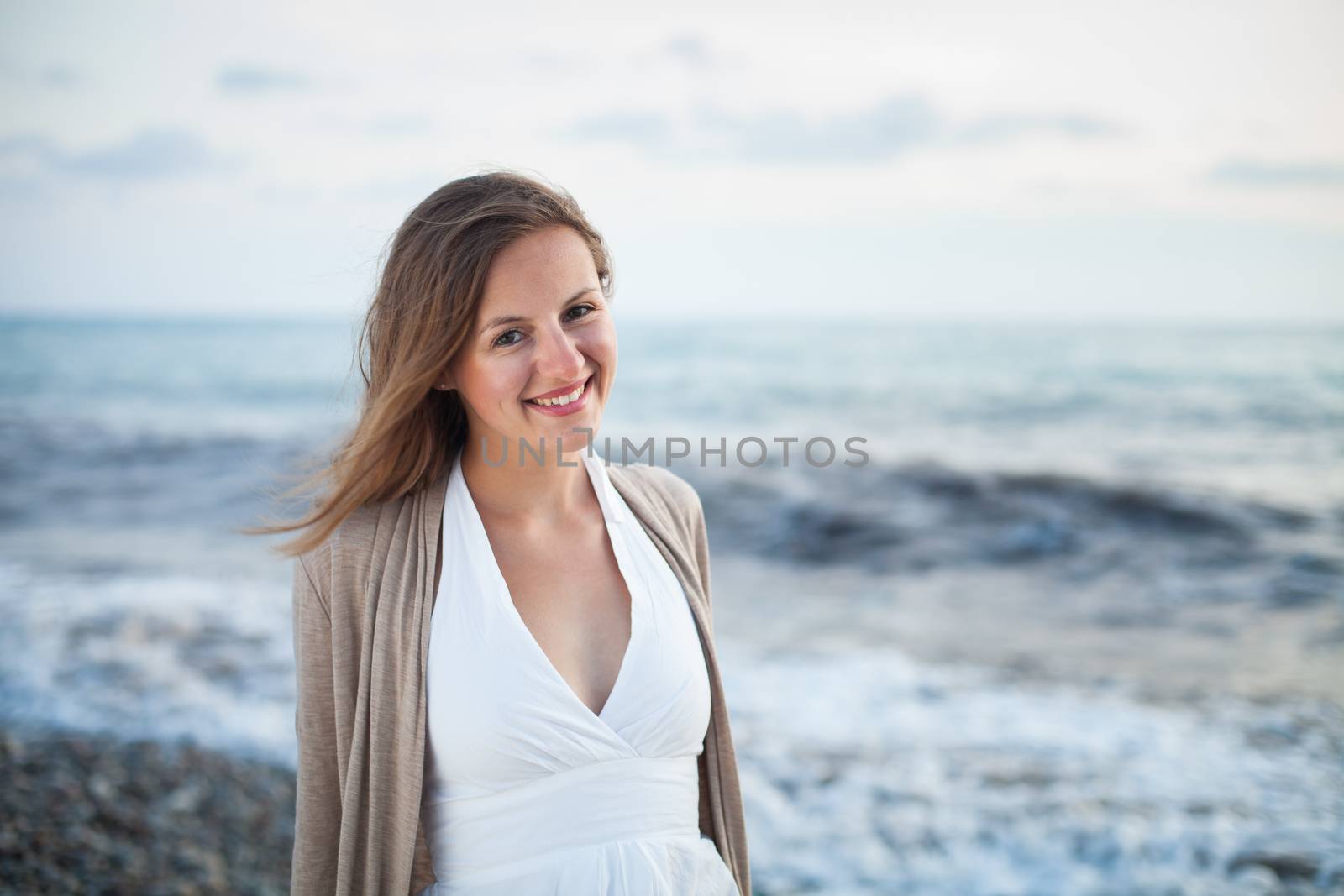 Young woman on the beach enjoying a warm summer evening on the seacoast