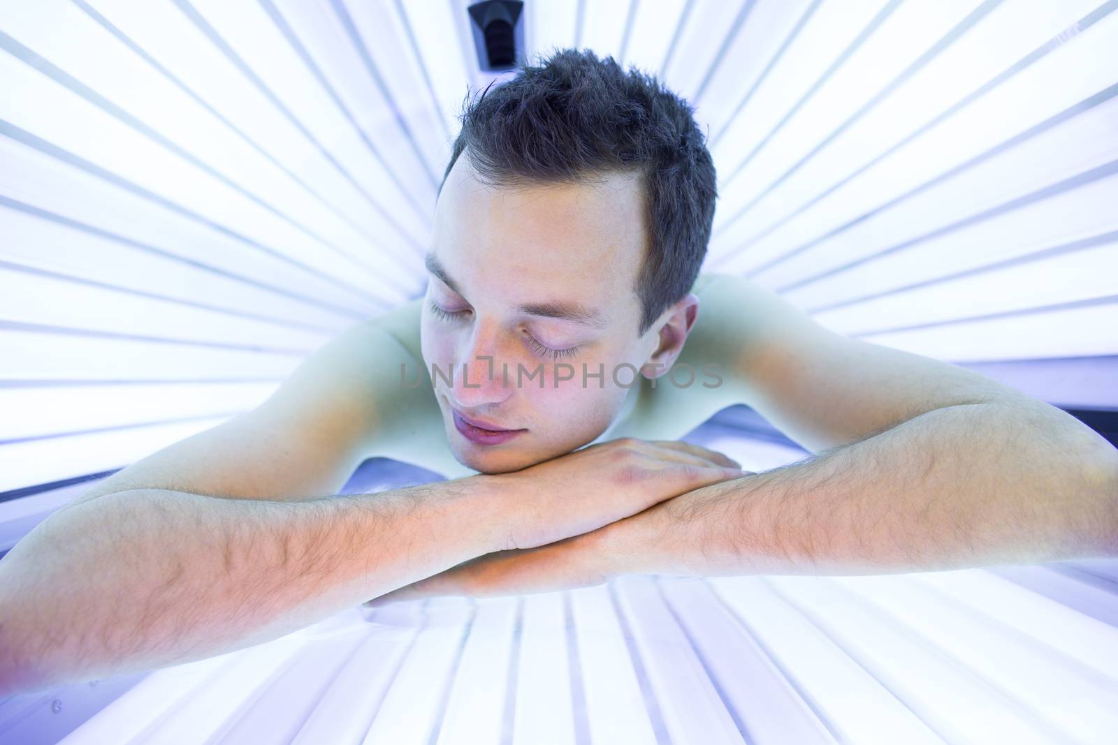 Handsome young man relaxing  in a modern solarium by viktor_cap