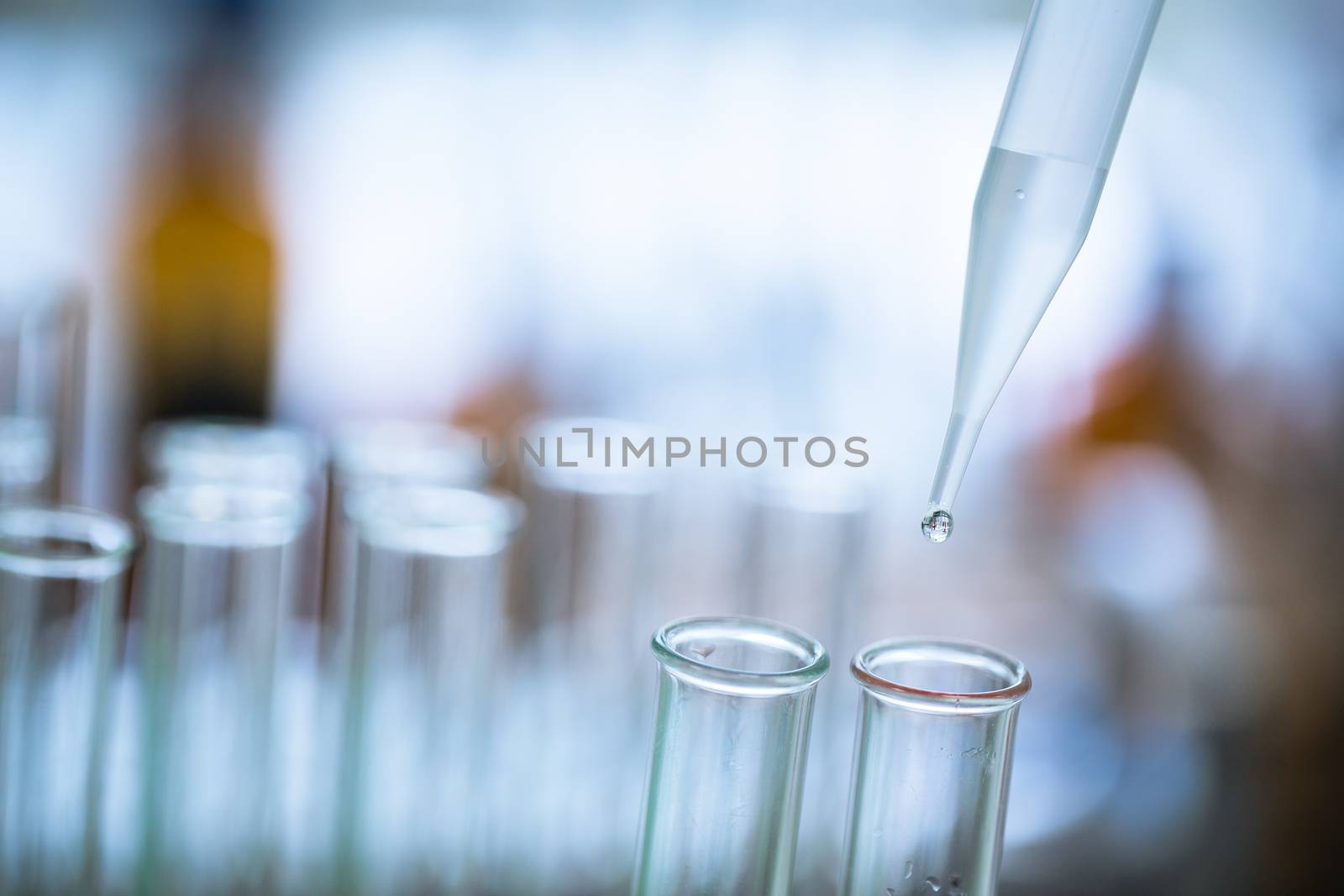 Liquid drop from laboratory glass pipette to test tube