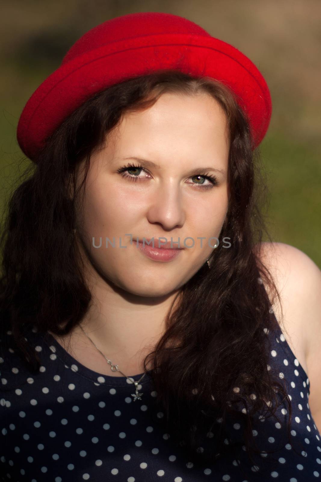 Young woman in red hat looks at the sun