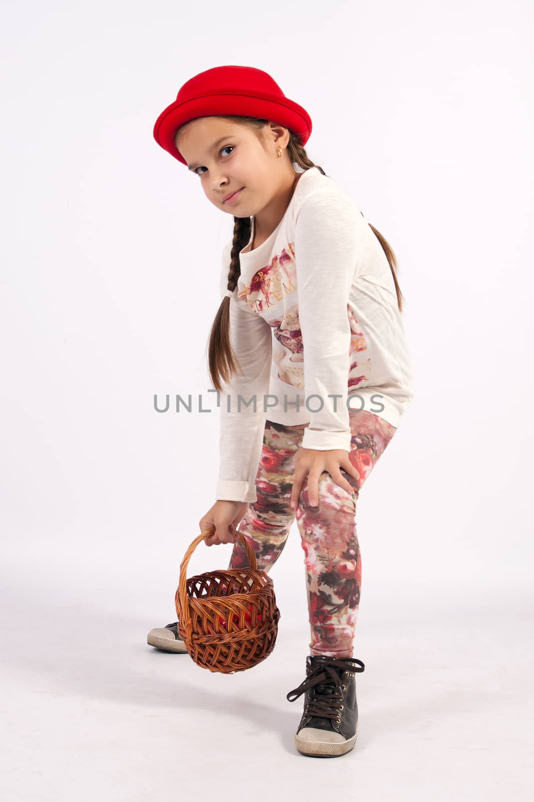 The little girl in a red hat, holding a hand basket