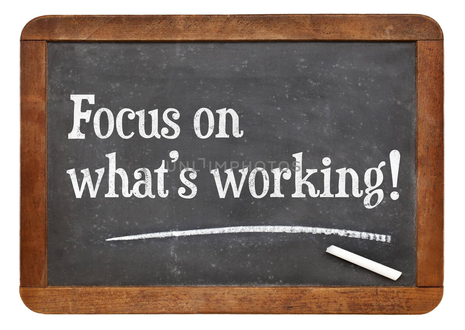 Focus on what is working. Motivational words on a vintage slate blackboard.