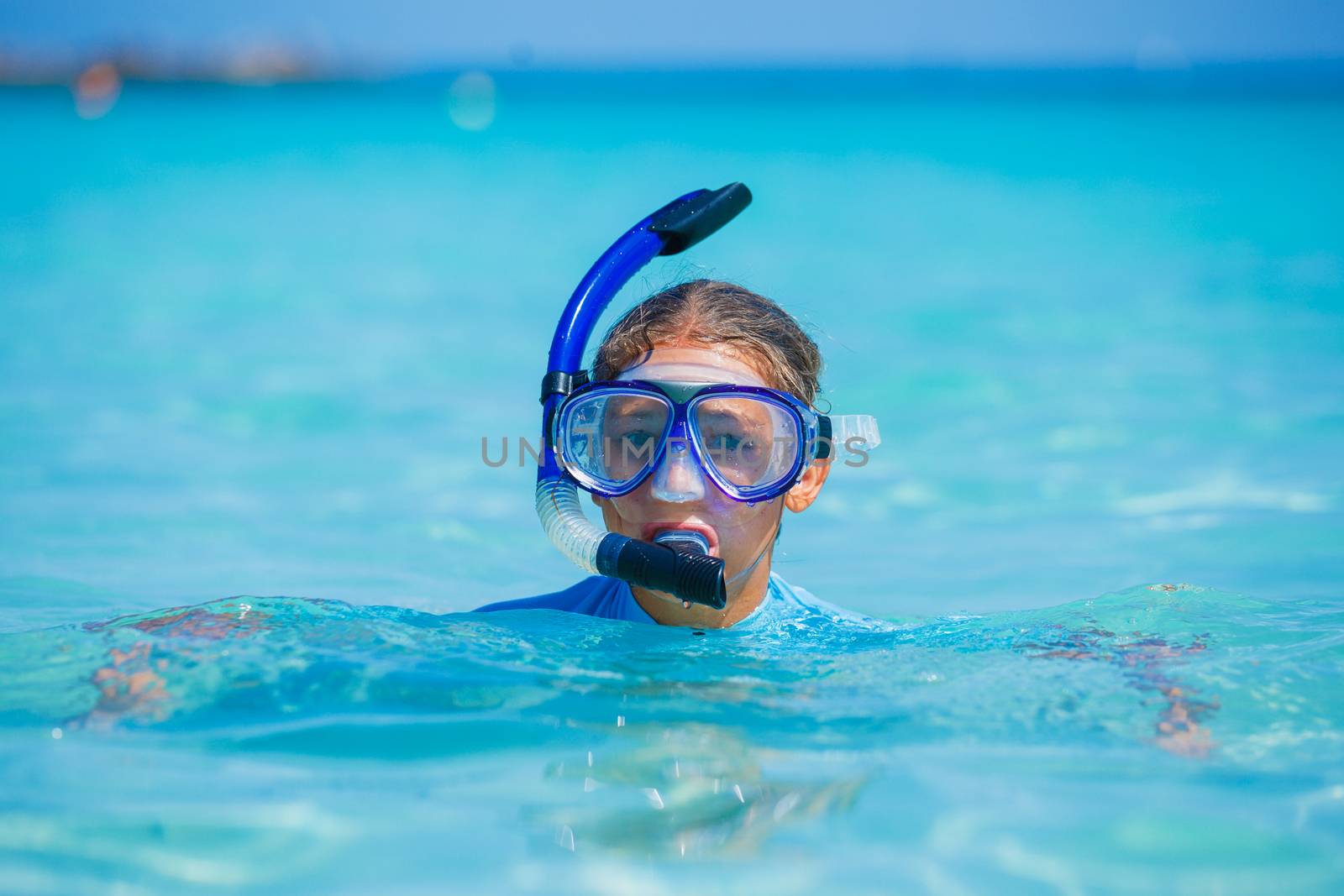 Portrait of happy cute girl wearing snorkeling mask ready to dive in the sea