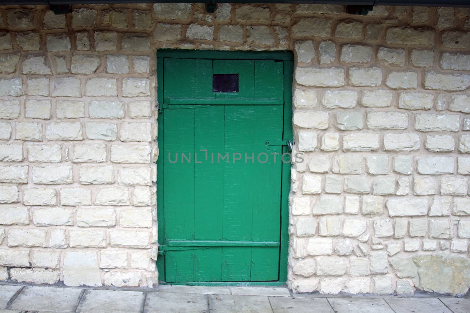 Old green door on the brick wall background