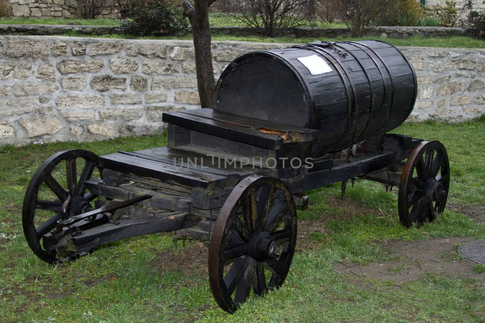 Vintage black barrel wagon transports water by mcherevan