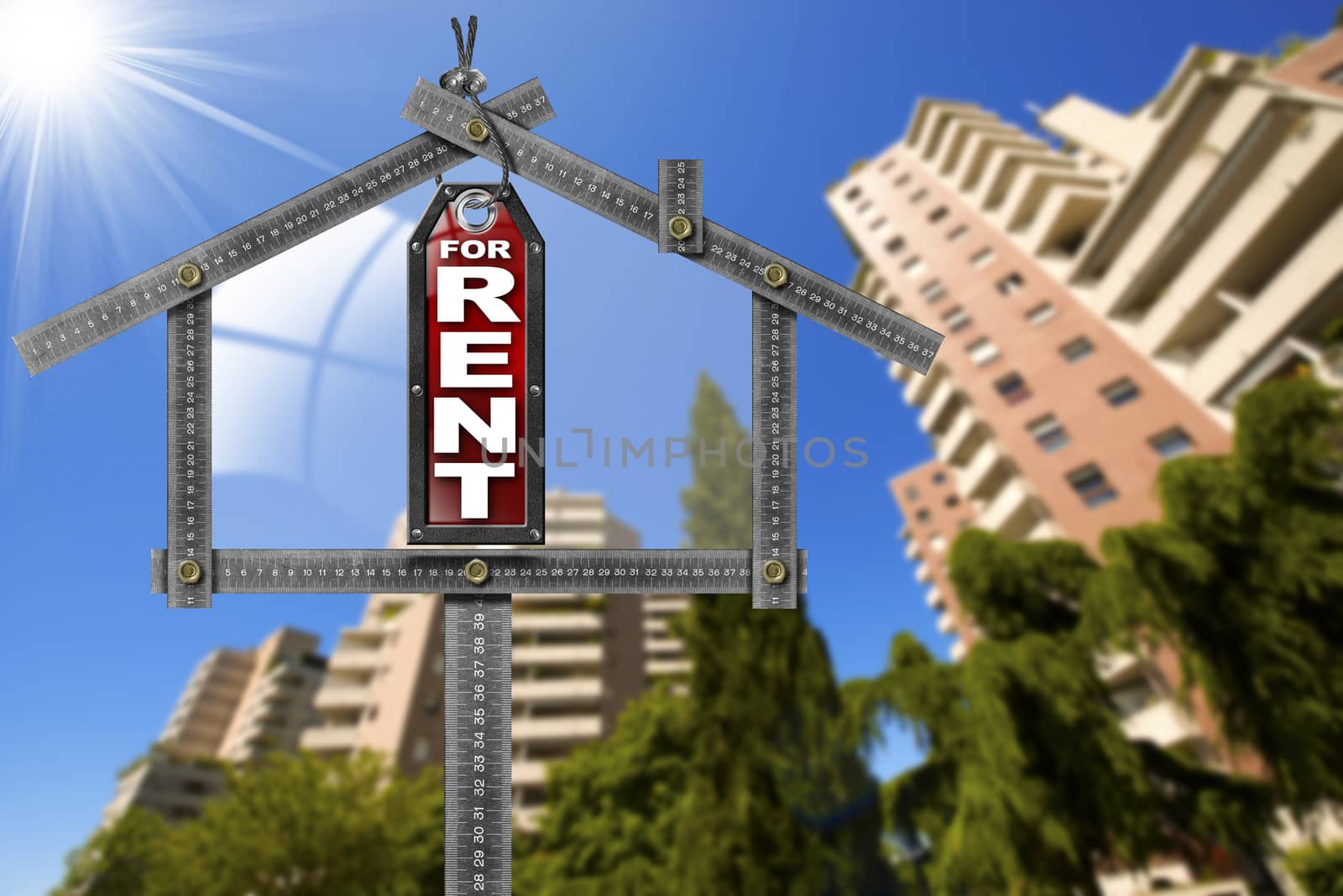 Grey metallic meter ruler in the shape of house and label with text for rent. For rent real estate sign with tall and blurred buildings in the background