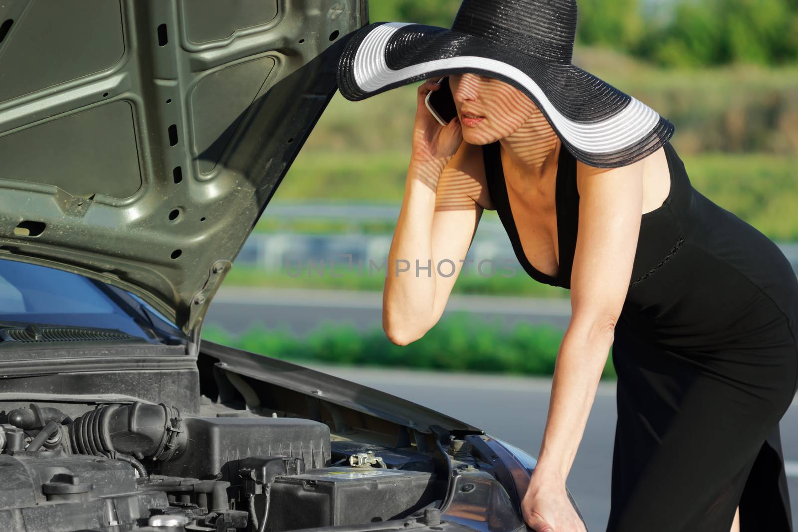 Woman with telephone near the broken car