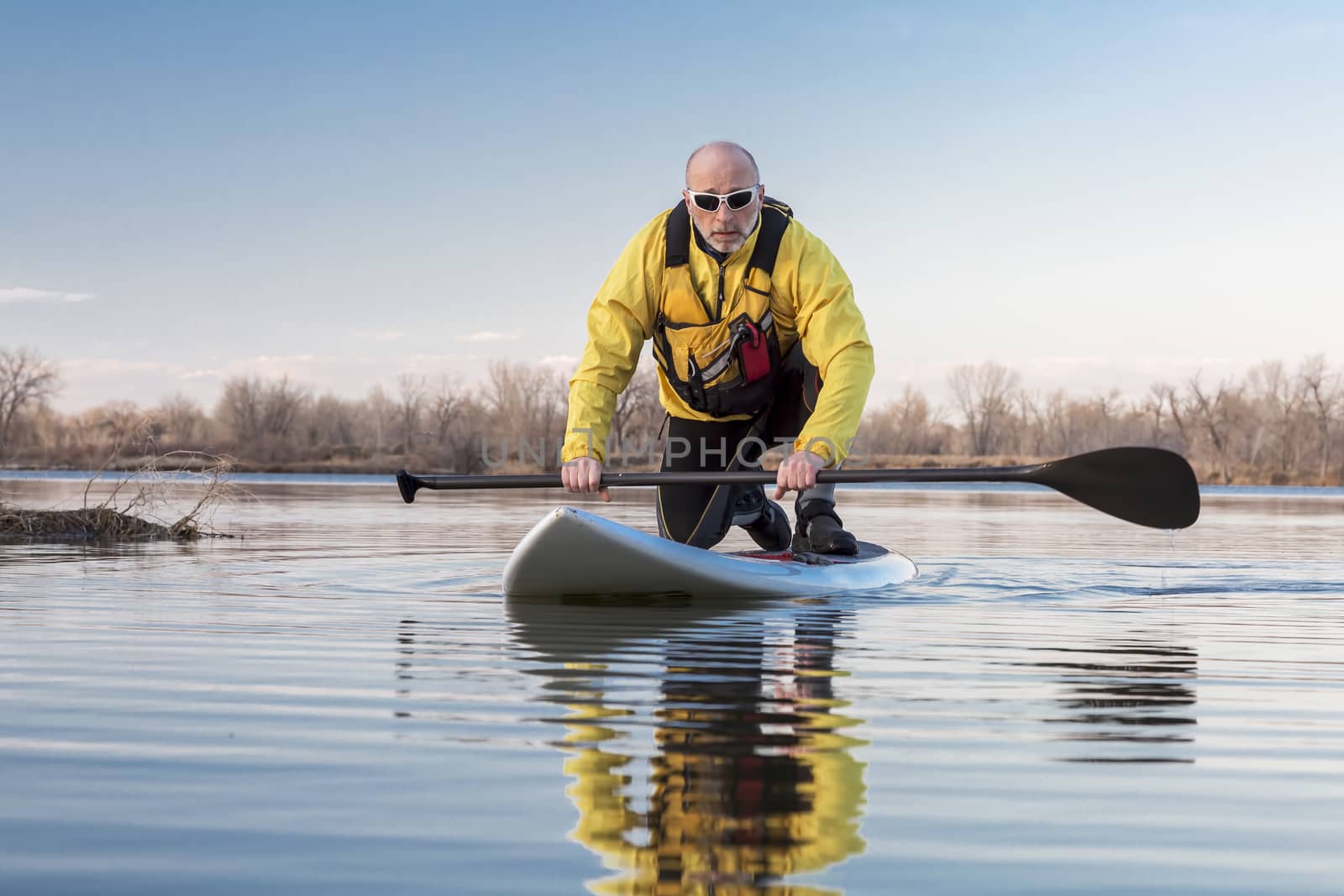 Senior male on stand up paddling (SUP) board by PixelsAway