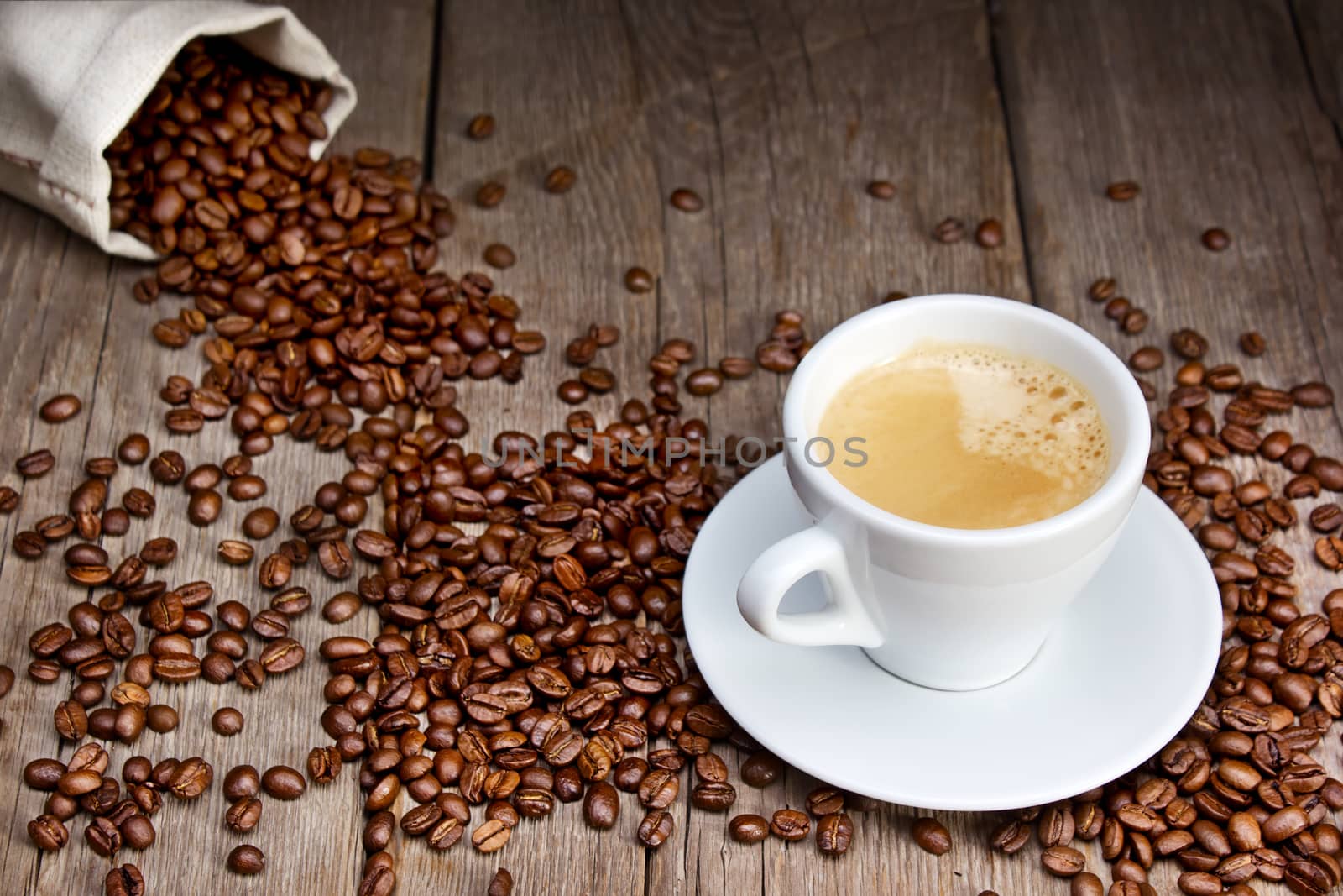 Coffee cup with beans on wooden background
