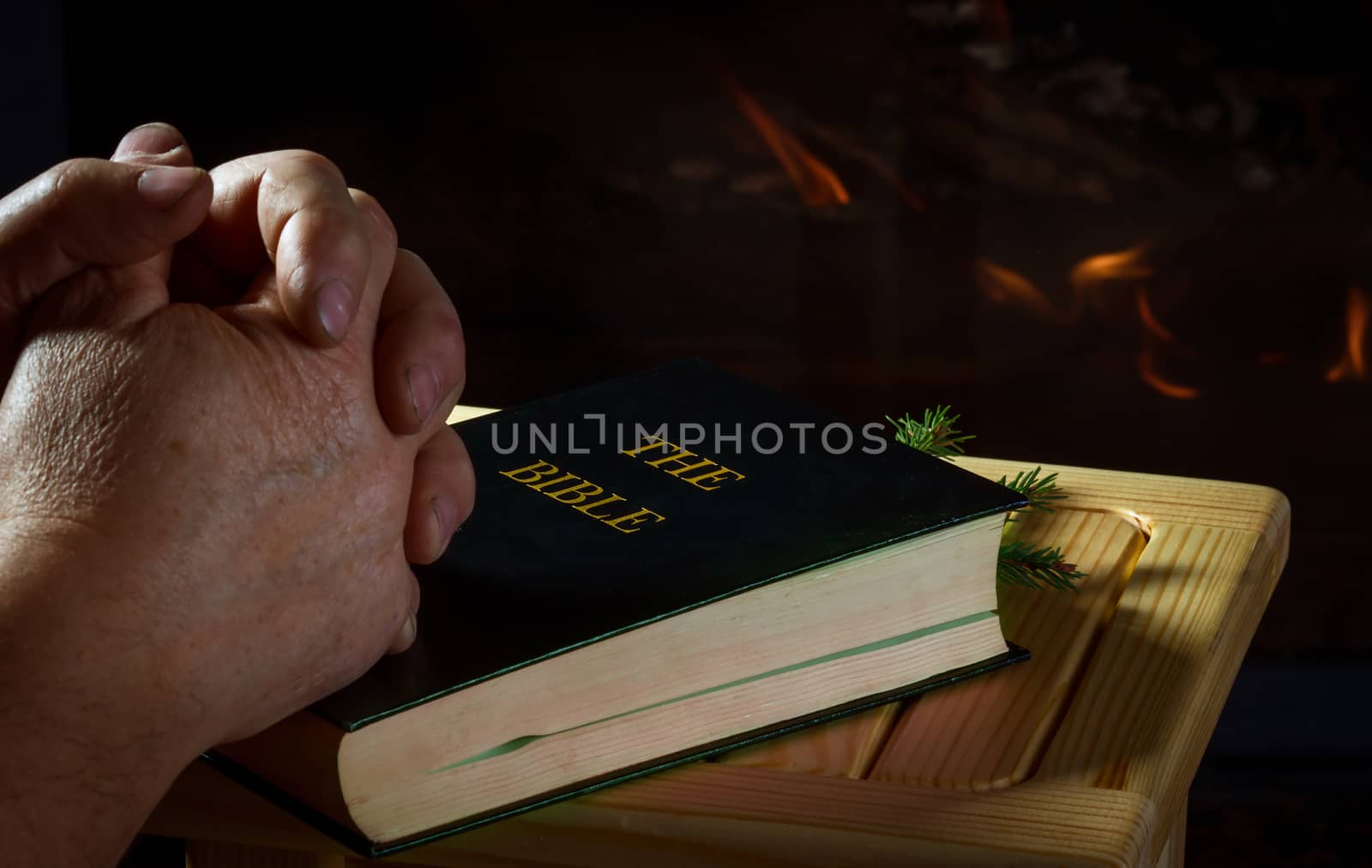 Hands of a man prying on fireplace background