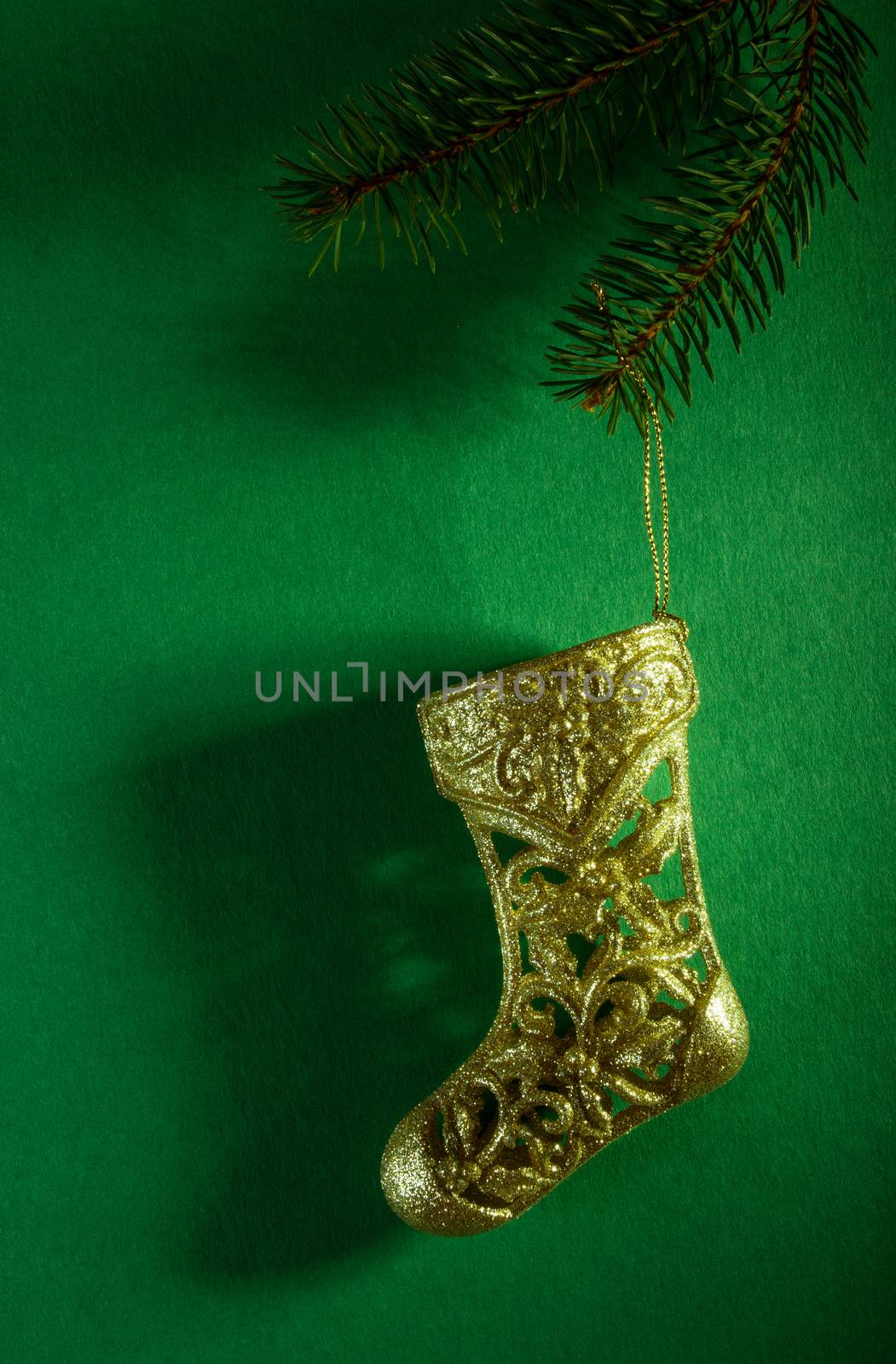 Christmas stocking: golden toy sock on green background