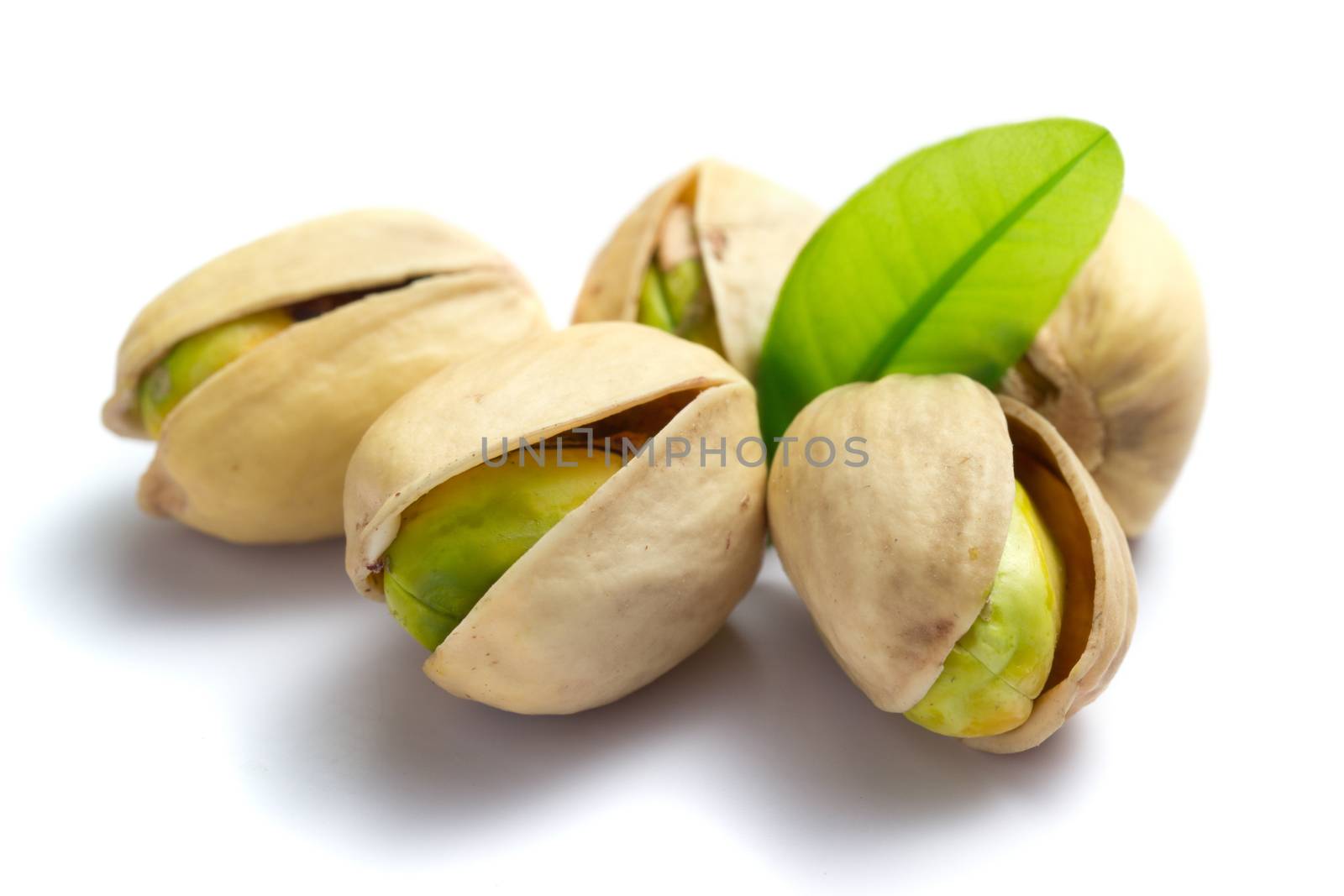 Pistachio nuts with leaf isolated on white