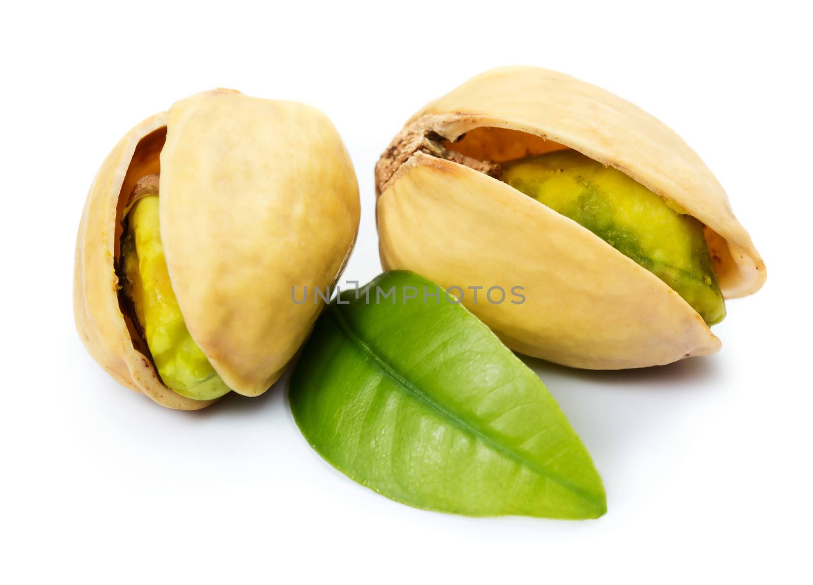 Two pistachio nuts with leaf isolated on white background