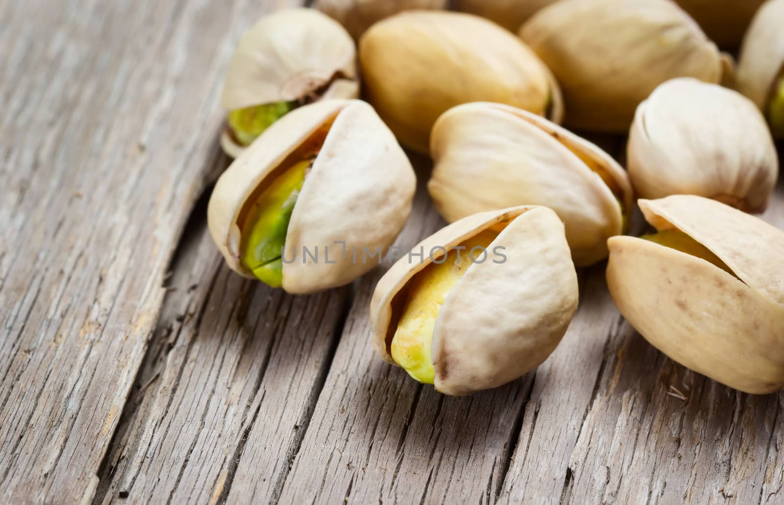 Pistachio nuts on wooden background